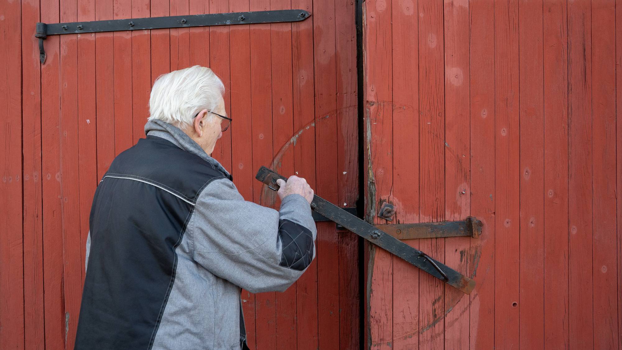 Hans Kristian Håkestad lukker porten på låven.