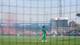 Christoffer Andersen / NTB Spiller i grønn drakt står på en fotballbane. Andre spillere er spredt utover banen. Tilskuerne er synlige bak et nett. Det er røyk på tribunen og bakspillere. (Bildebeskrivelsen er laget av en KI-tjeneste)