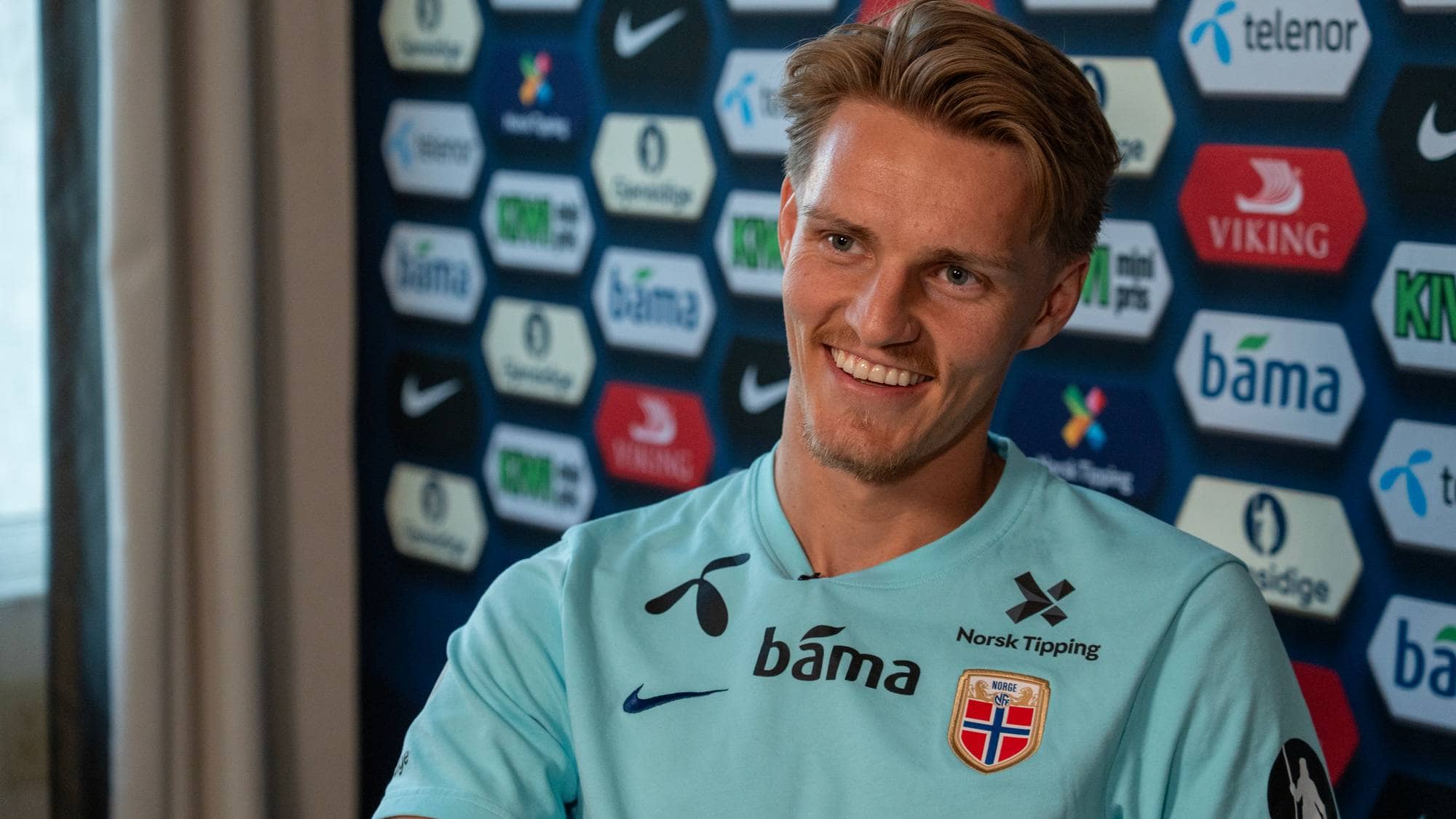 Norsk fotballspiller på et hotellrom blir intervjuet