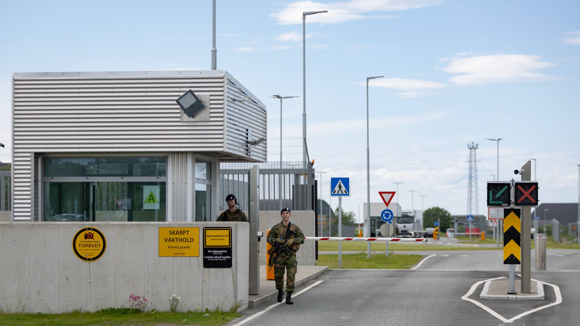 Bevæpnede soldater ved vakthold ved inngangen til en militærbase. (Bildebeskrivelsen er laget av en KI-tjeneste)