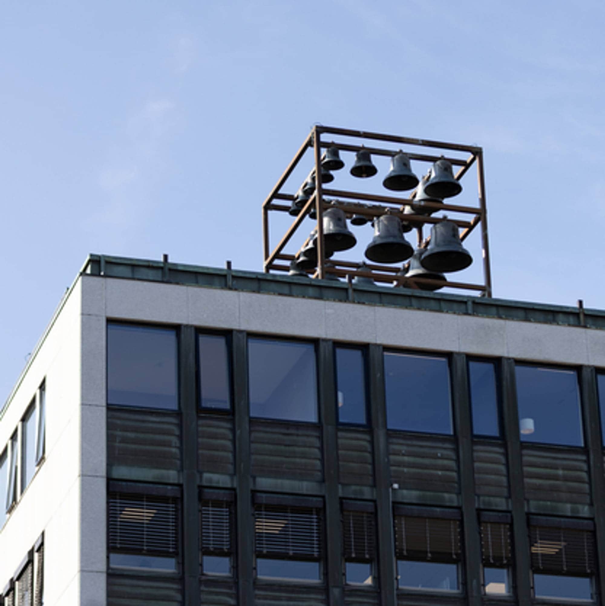 En bygning, med flere klokker på toppen som spiller hver time. 