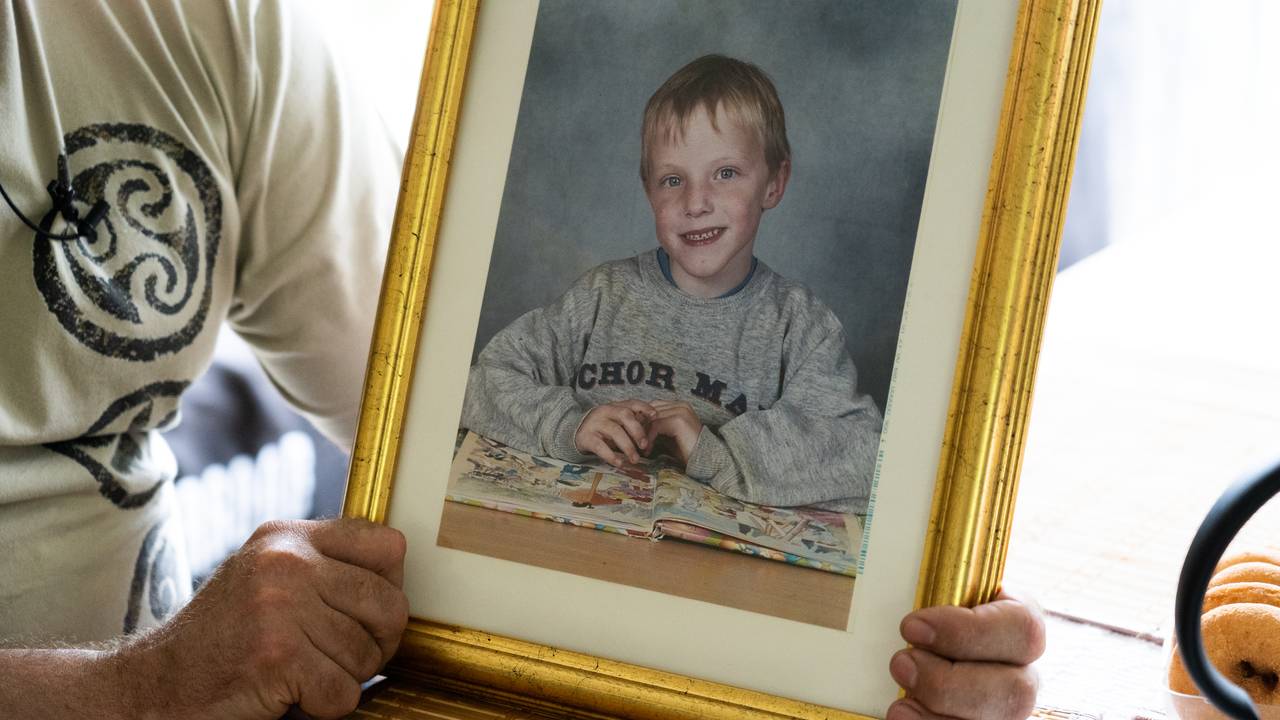 Roger Åsheim holder bildet av sønnen Johannes som ble angrepet av seks hunder og døde.