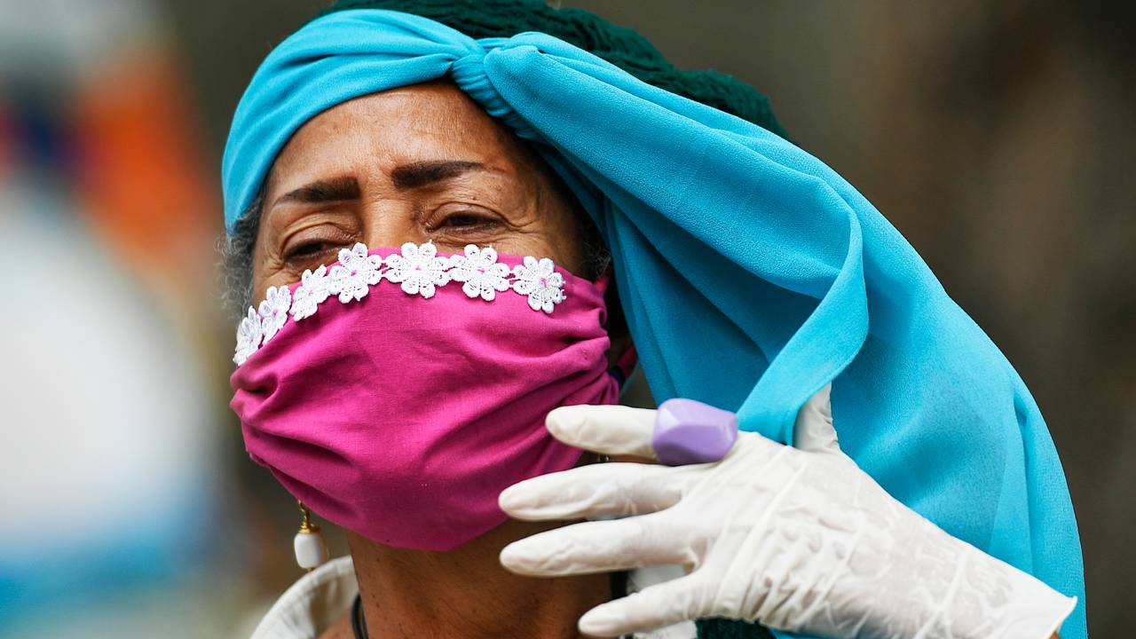 En kvinne med maske, hansker og skaut tar seg en pause utenfor et sykehjem i Venezuelas hovedstad Caracas lørdag.