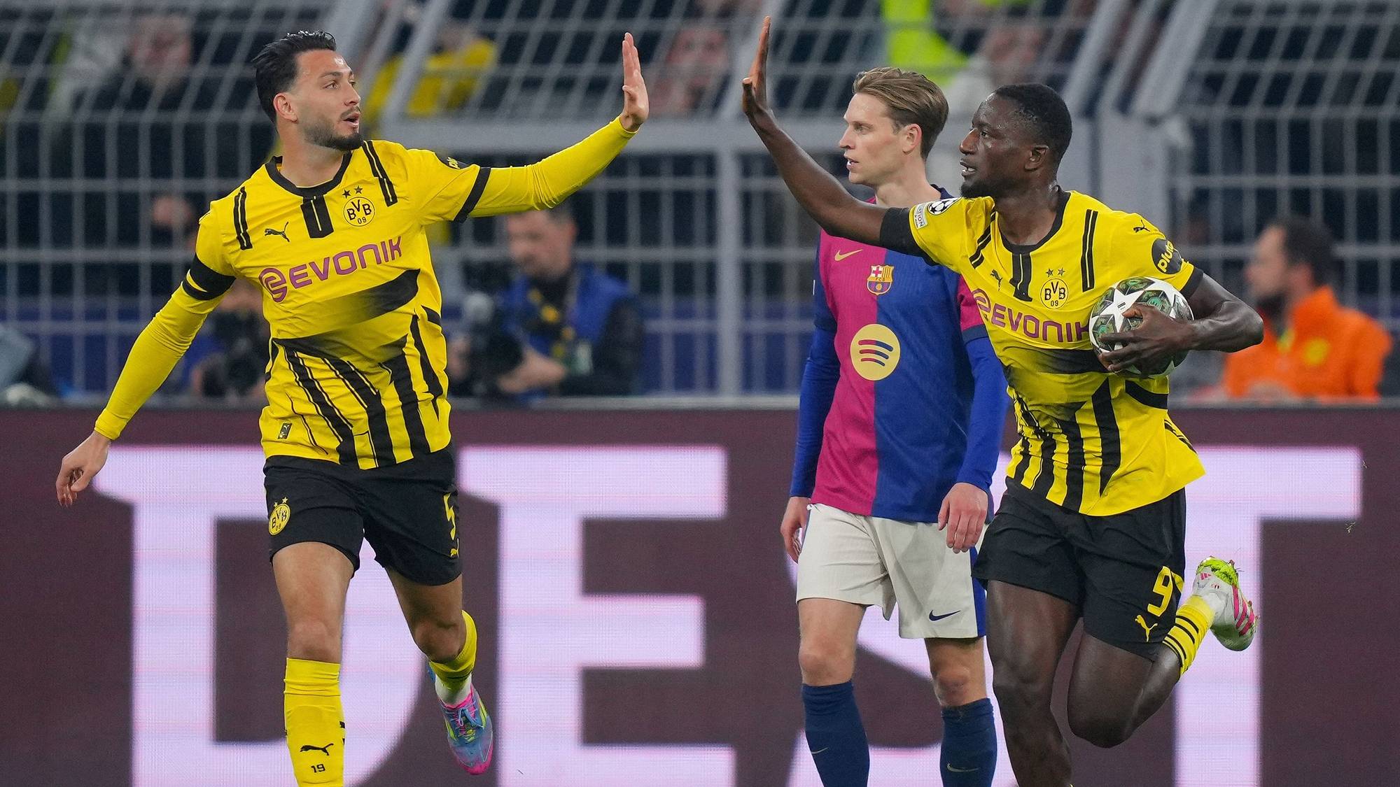 Dortmund's Guinean forward #09 Serhou Guirassy (R) celebrates scoring the opening goal from the penalty spot with his teammate Algerian defender #05 Ramy Bensebaini 
