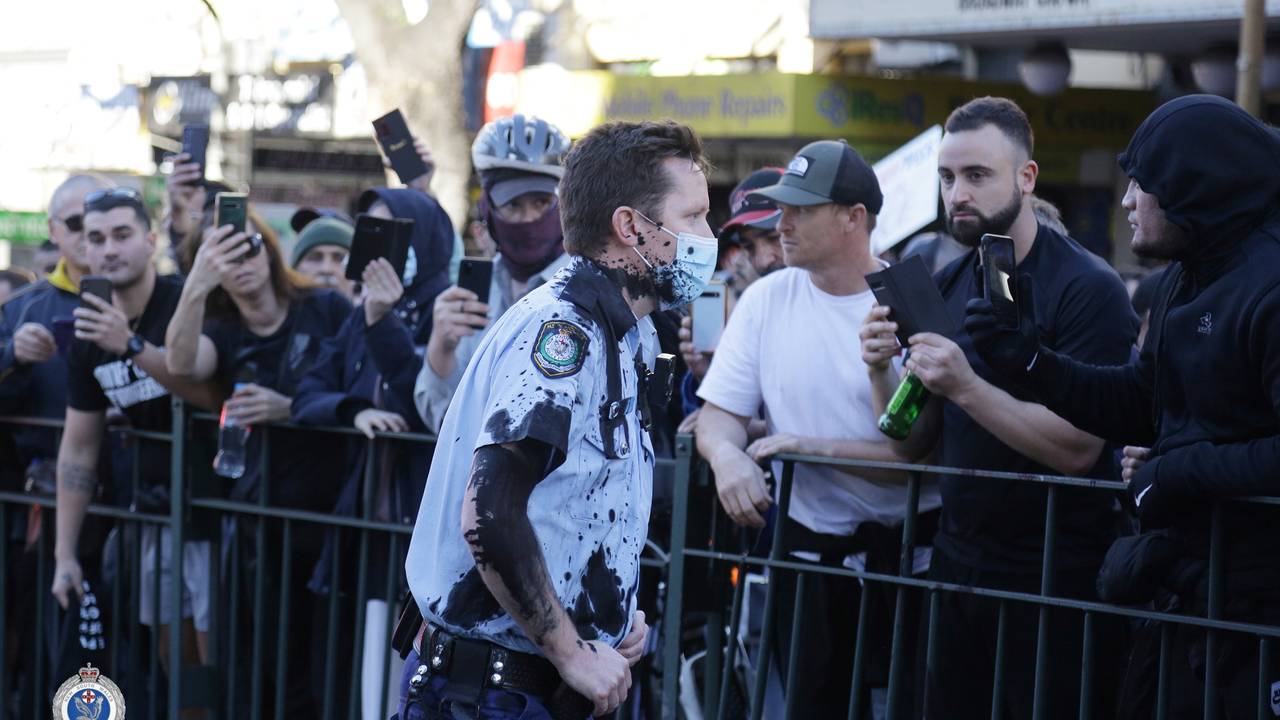 A police officer is covered in black ink after clashes at an anti-lockdown demonstration in Sydney