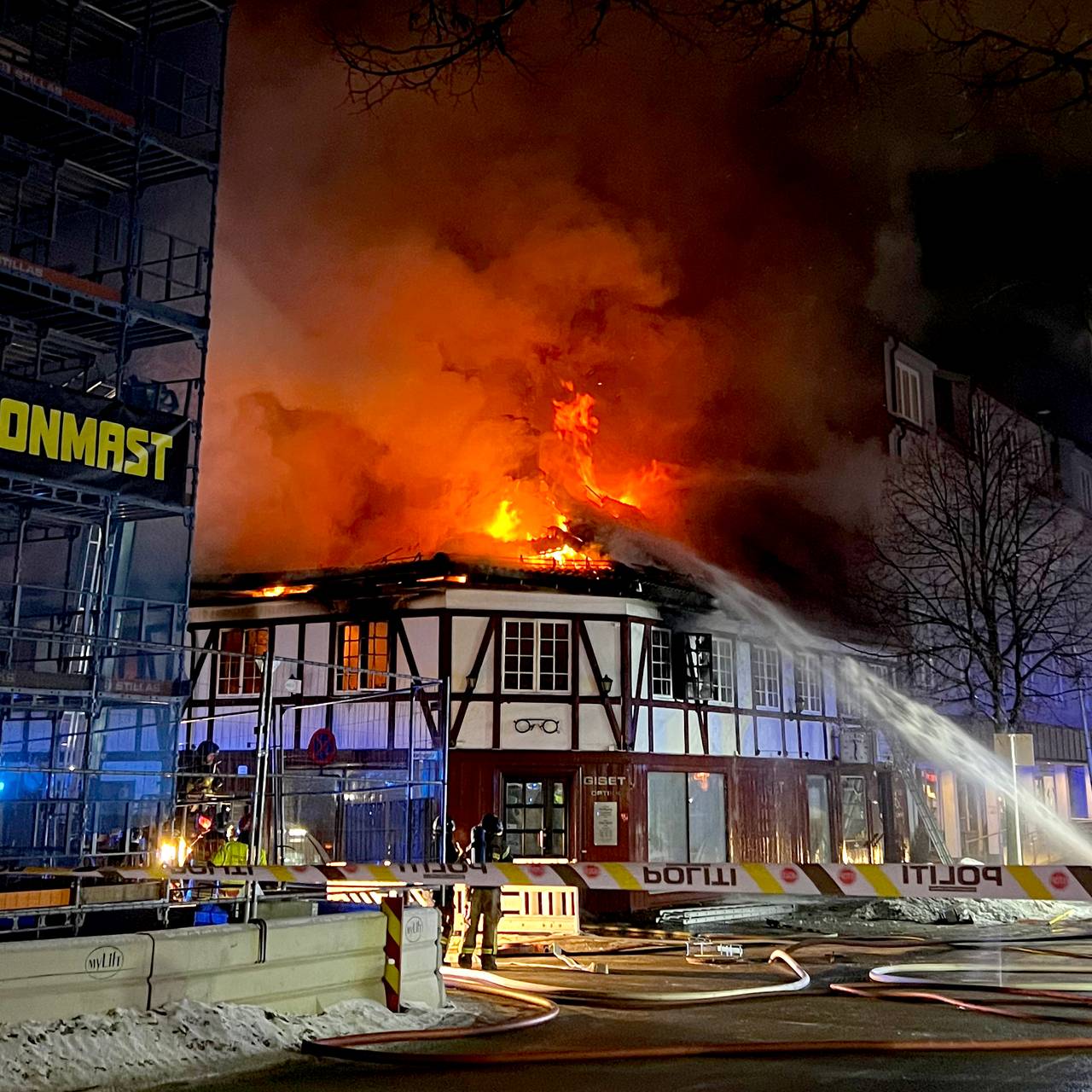 Brann i Gisegården i Hamar. Flammene slår gjennom taket.
