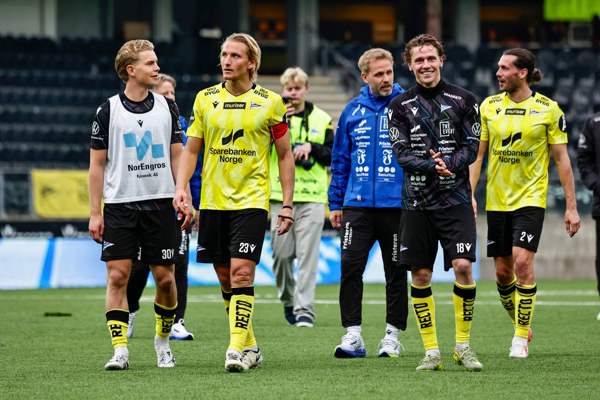 viser flere menn i drakter som går på en bane