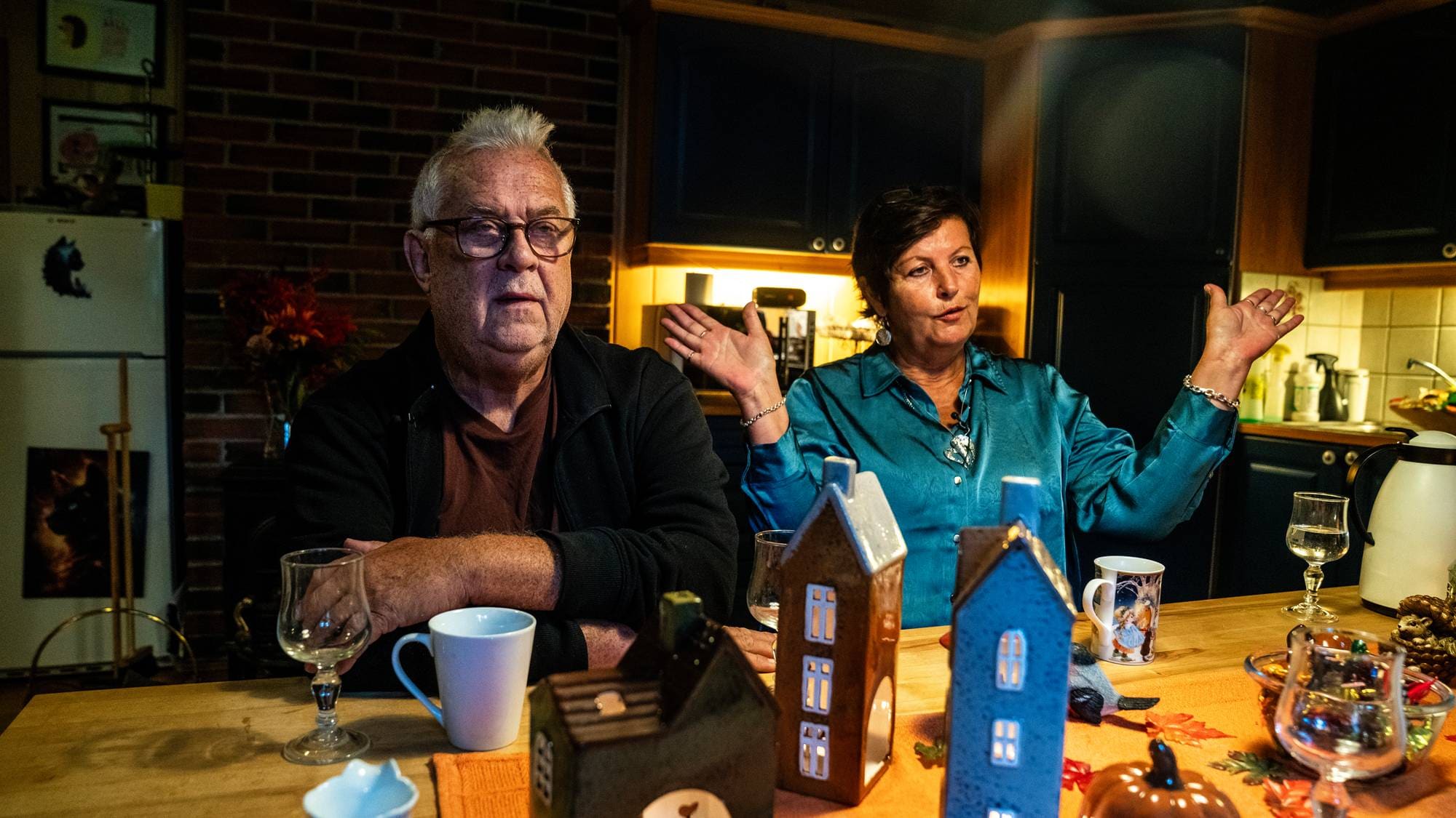 En mann og en kvinne sitter ved et spisebord i en stue. Kvinnen gestikulerer med hendene. (Bildebeskrivelsen er laget av en KI-tjeneste)