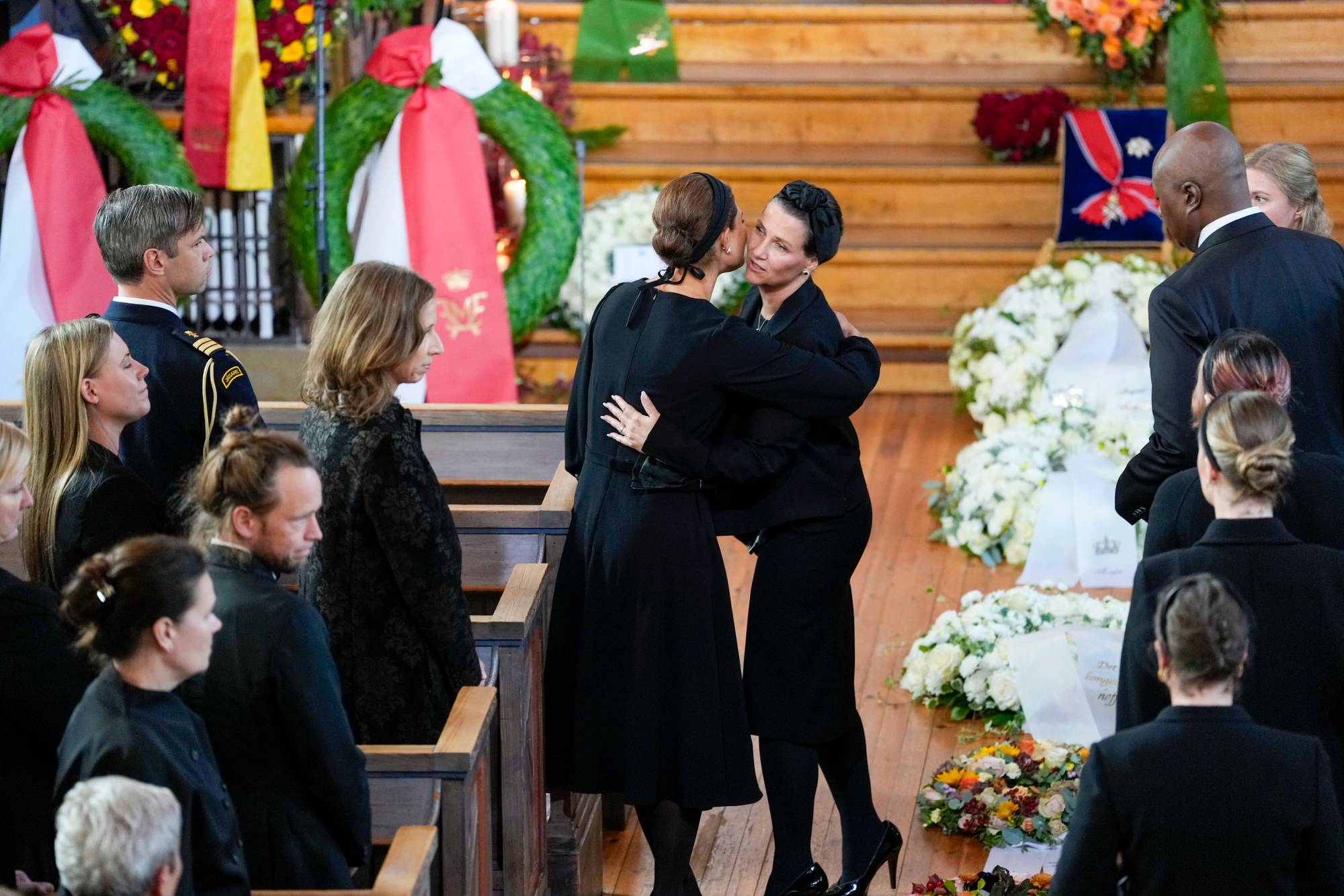 to kvinner i sore klær klemmer i en kirke