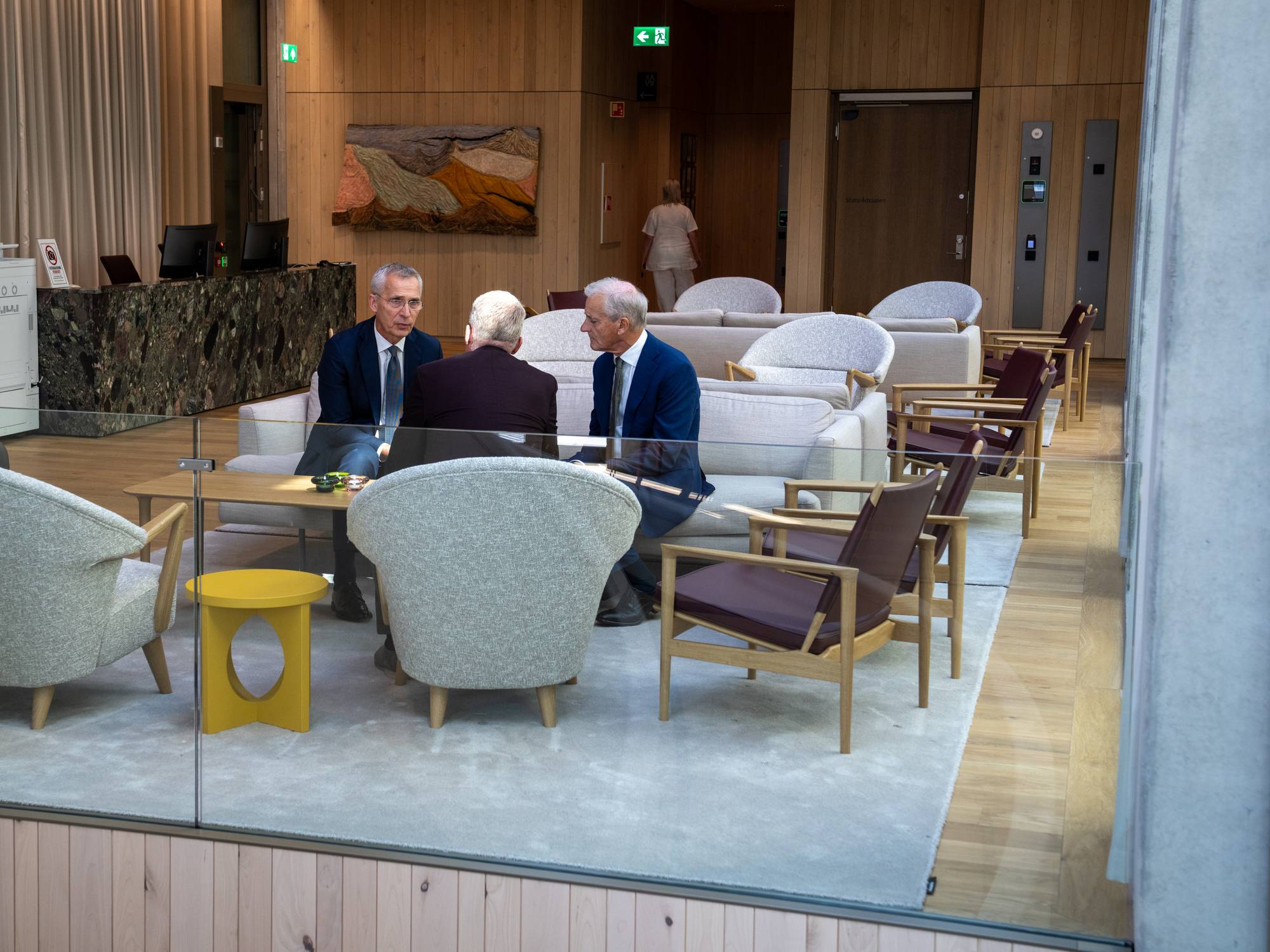 Finansminister Jens Stoltenberg og statsminister Jonas Gahr Støre intervjues før årets siste budsjettkonferanse på Statministerens kontor. Stills er tatt på forværelset til Statministerens nye kontor i D-blokka i det nye Regjeringskvartalet. Ellers er Stoltenberg og Støre på balkongen utenfor SMK. Stoltenberg viser Støre Arbeiderpartiets hovedkontor i Folketeaterbygningen på Youngstorvet, som skimtes i bakgrunnen. 