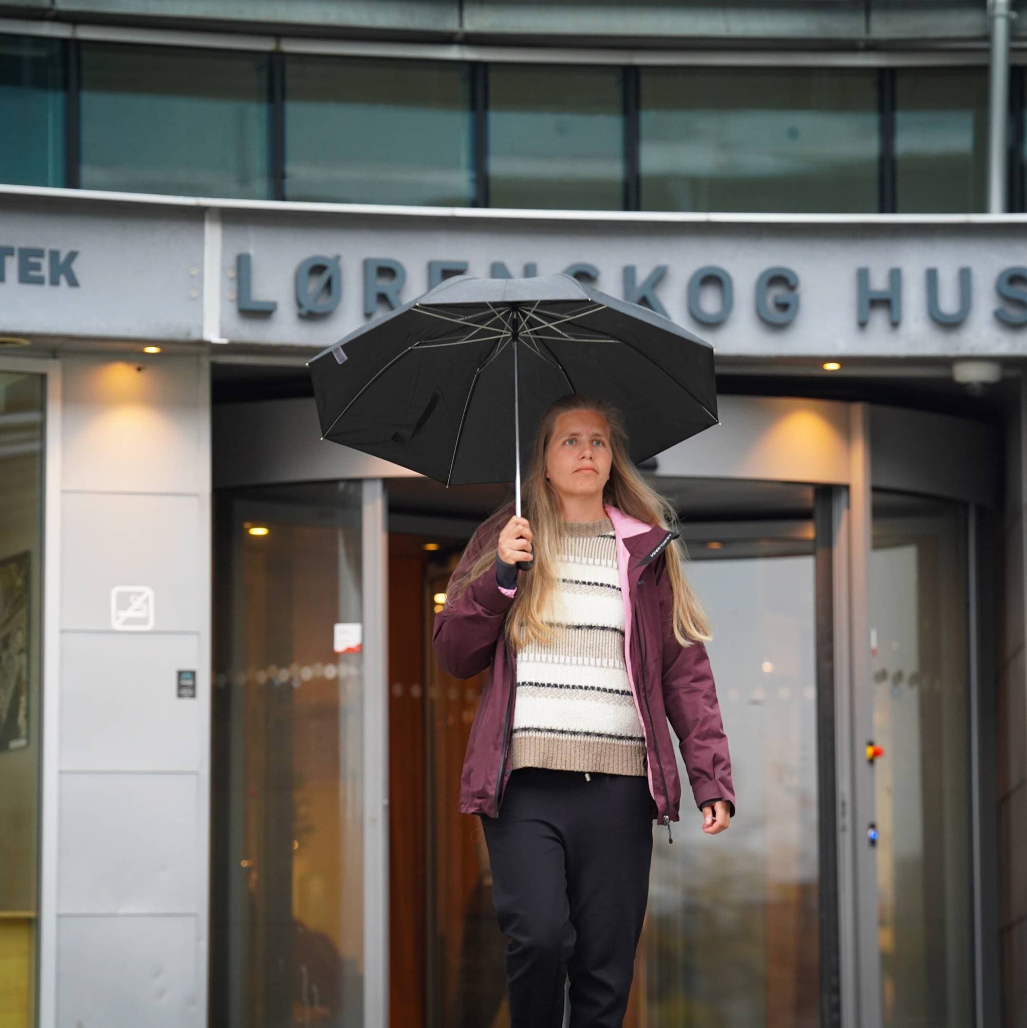 Dame med paraply utenfor Lørenskog hus