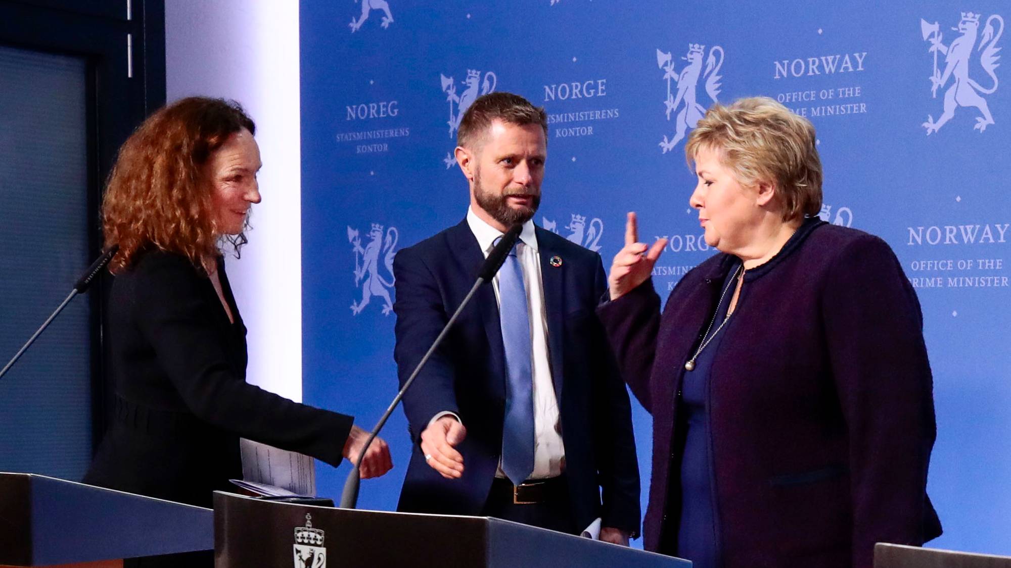 Bent Høie står på et podium med en kvinne stående bak seg