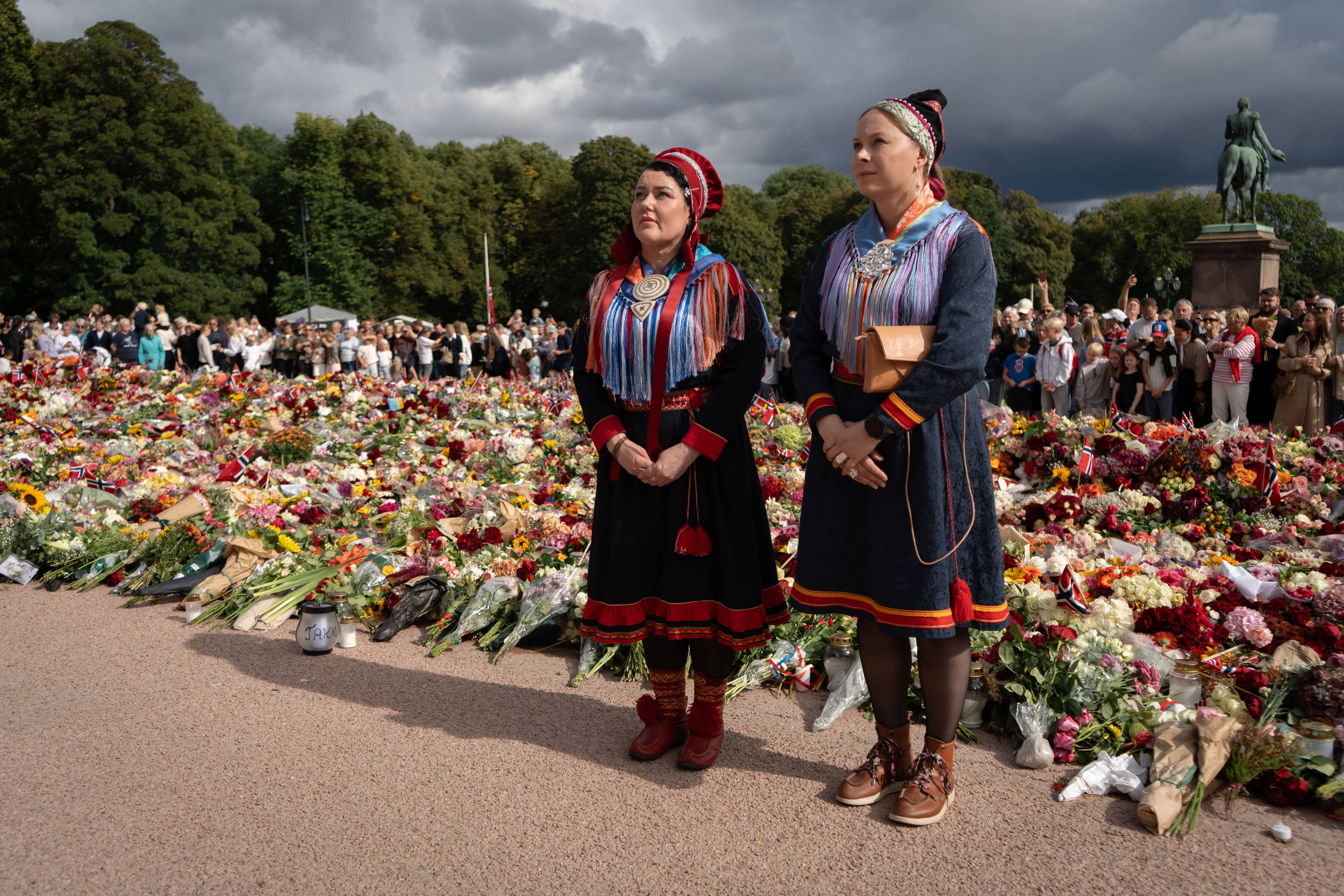 Silje Karine Muotka og Sandra Márjá West la ned blomster på Slottsplassen.
