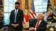 JIM WATSON / AFP / NTB En mann står ved et skrivebord i et kontor, mens en annen mann sitter ved bordet. Kontoret har store vinduer med gardiner og er dekorert med nasjonale flagg. Begge mennene er kledd i formelle klær og ser mot hverandre. Det er flere bilder og et symbol på skrivebordet.