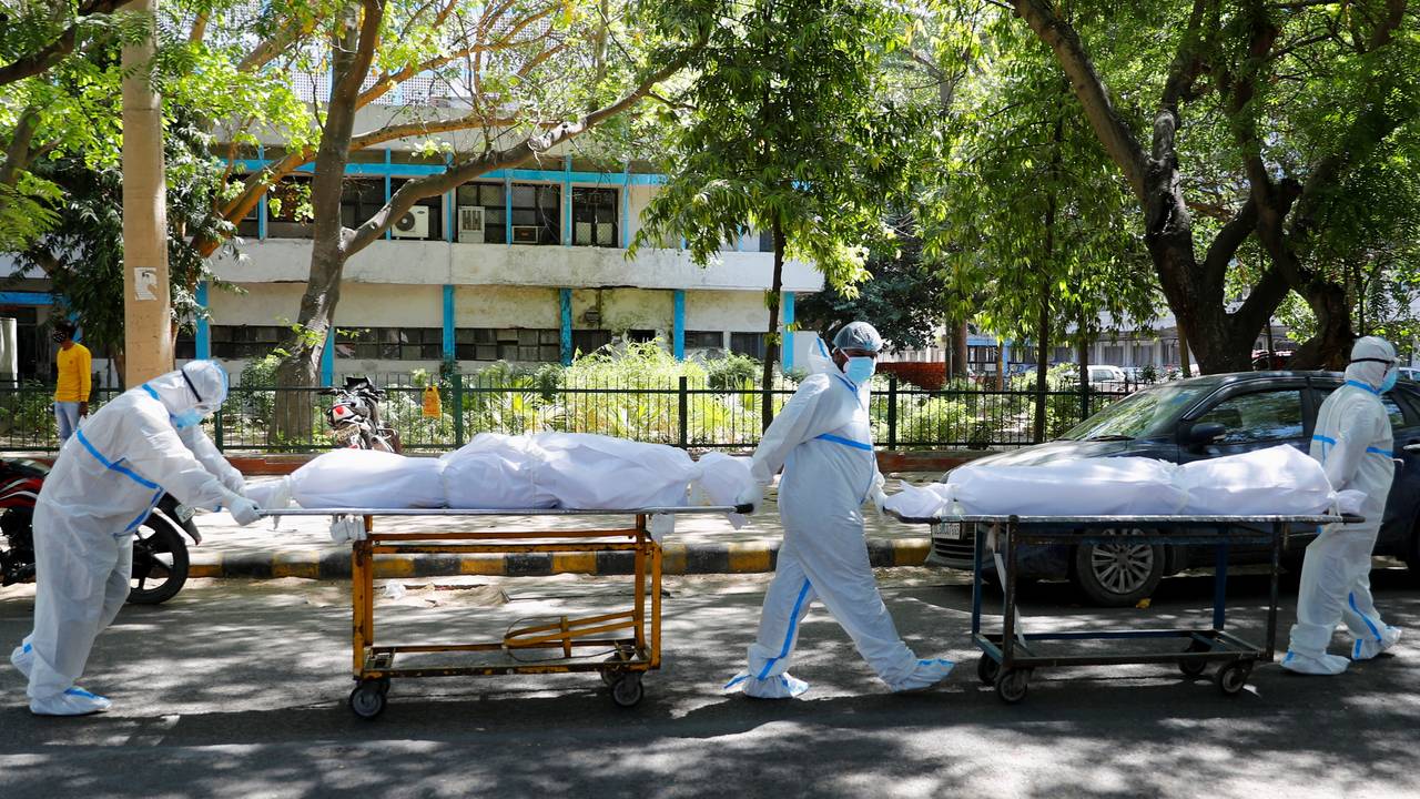 Helsearbeidere med beskyttelsesutstyr frakter døde etter koronasykdom utenfor Guru Teg Bahadur-sykehuset i New Dehli, India.