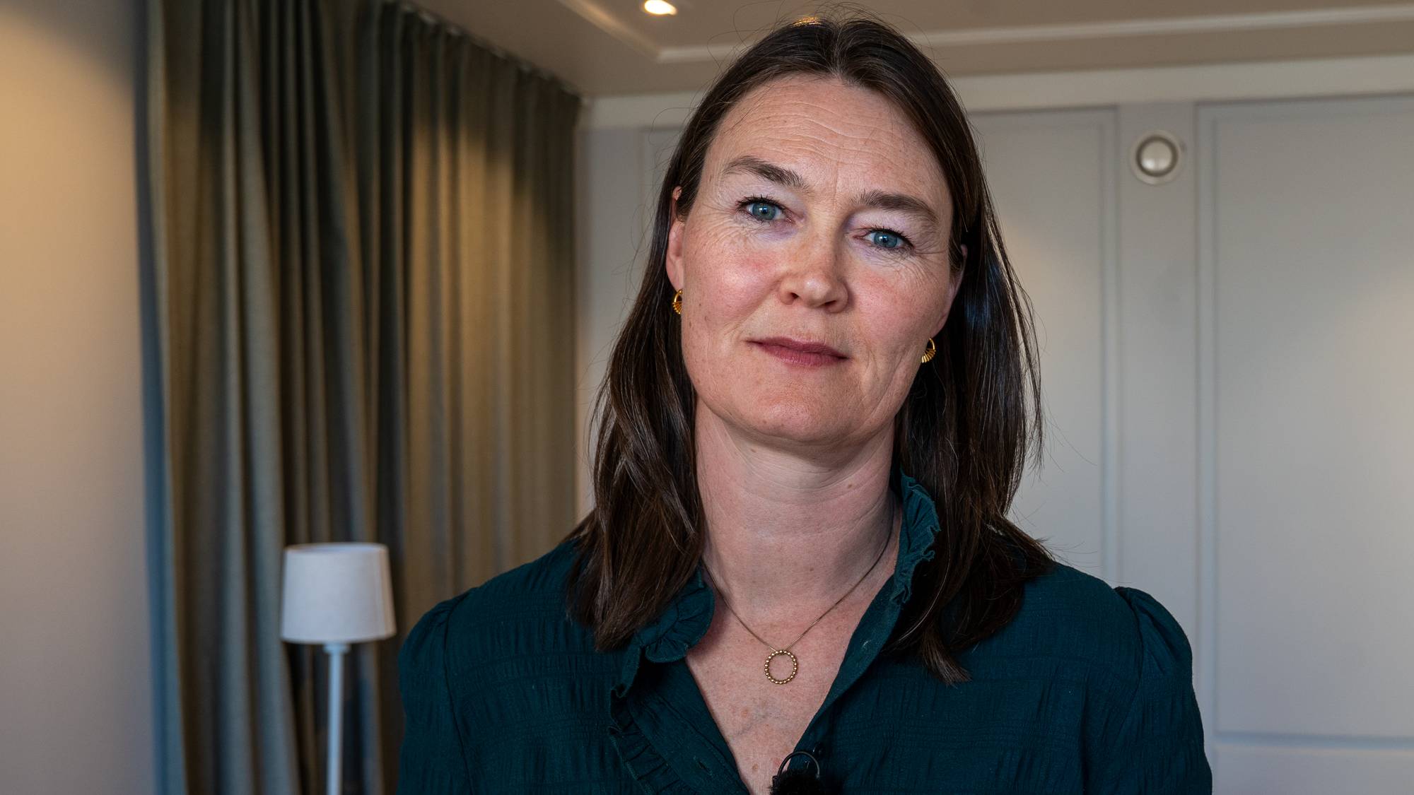 Kvinne med mørkt hår ser i kamera