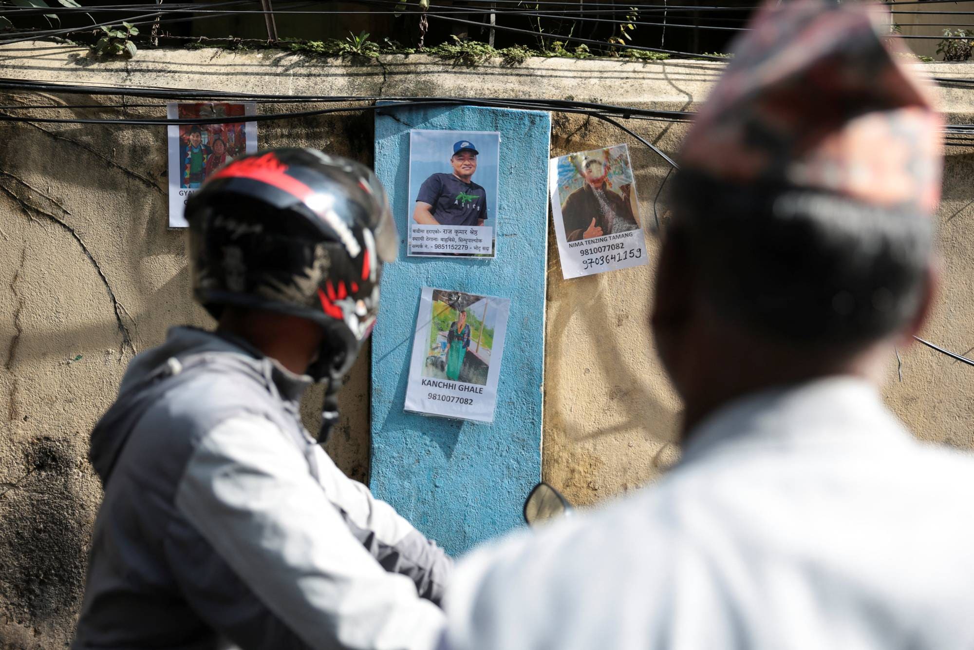 Folk ser på bilder av savnede på en vegg i et traumesenter i Kathmandu.