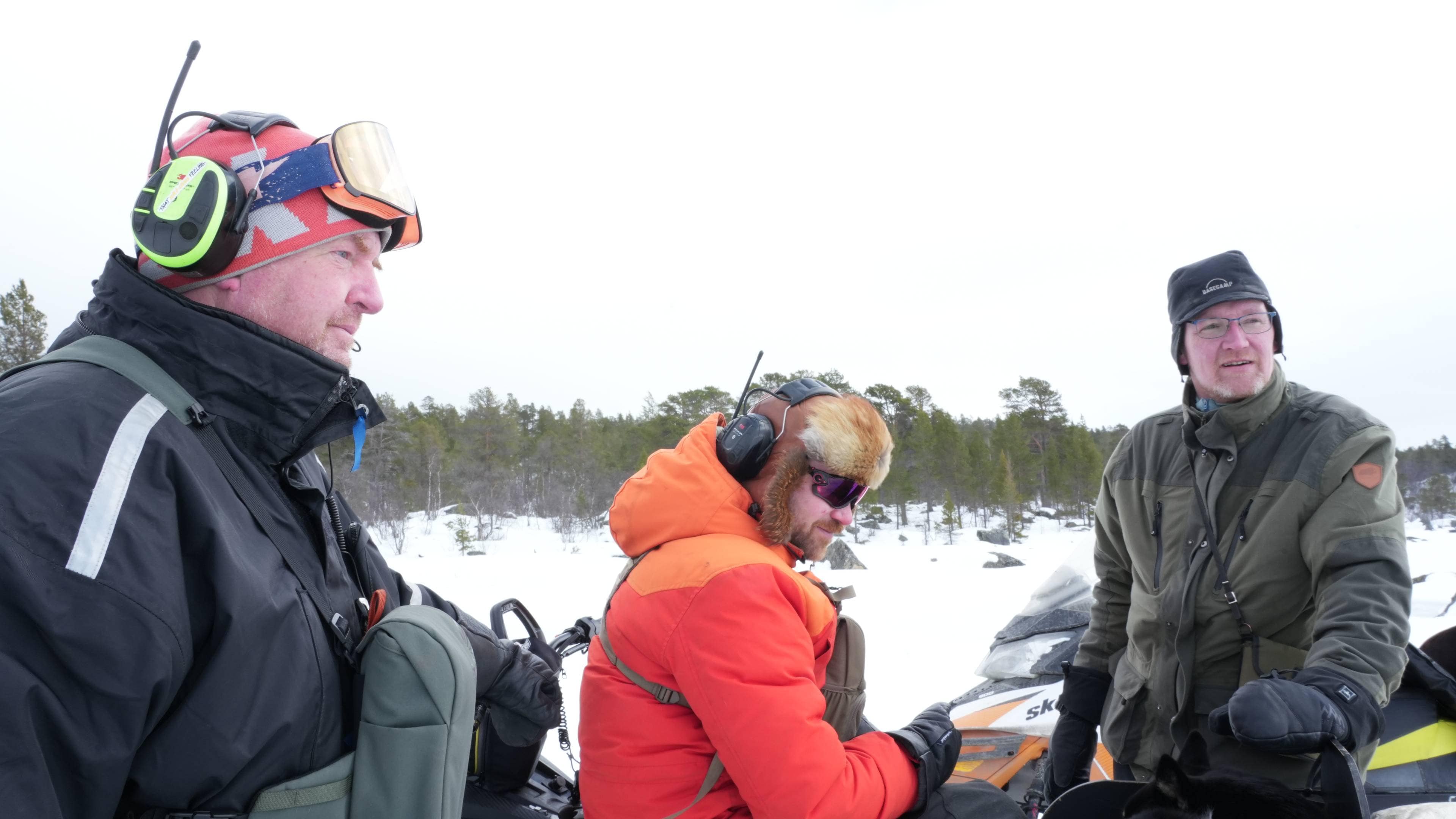 En gruppe mennesker rundt en snøskuter