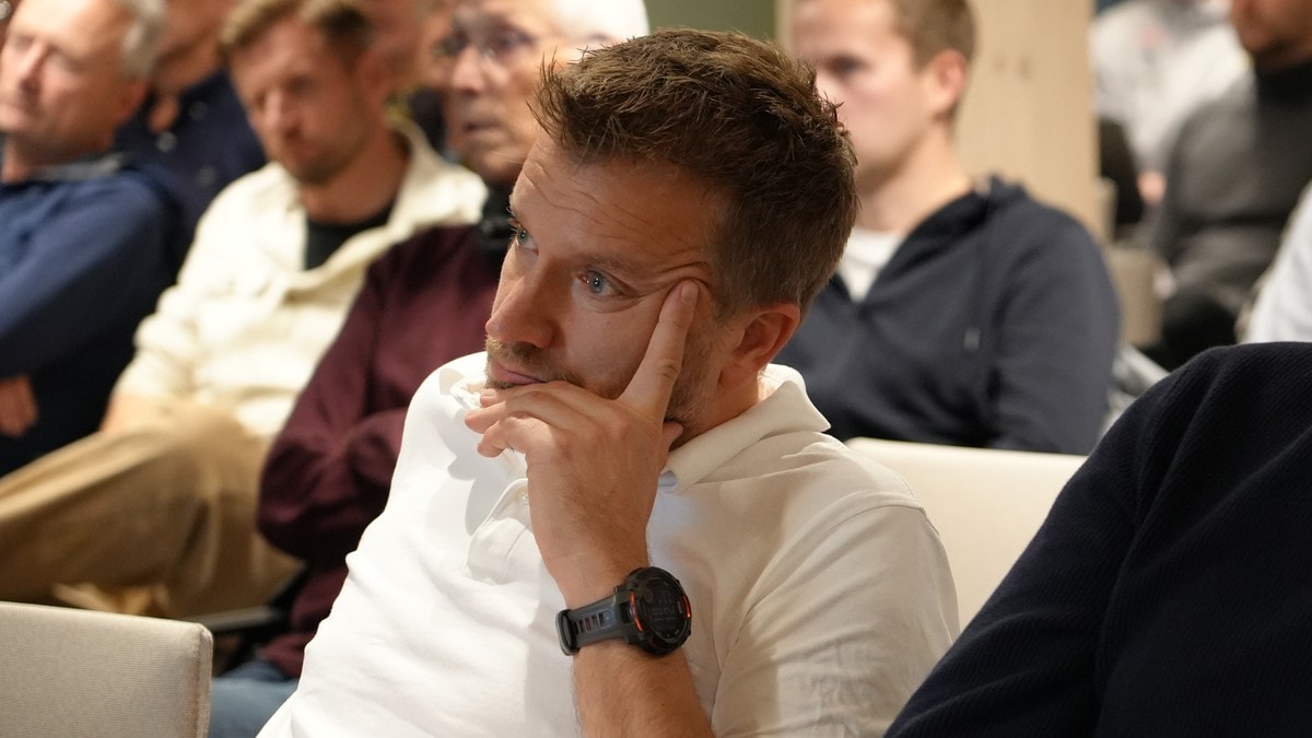En gruppe menn sitter i en forsamling og følger med på et arrangement. (Bildebeskrivelsen er laget av en KI-tjeneste) FOTO: Ingeborg Grindheim Slinde/NRK