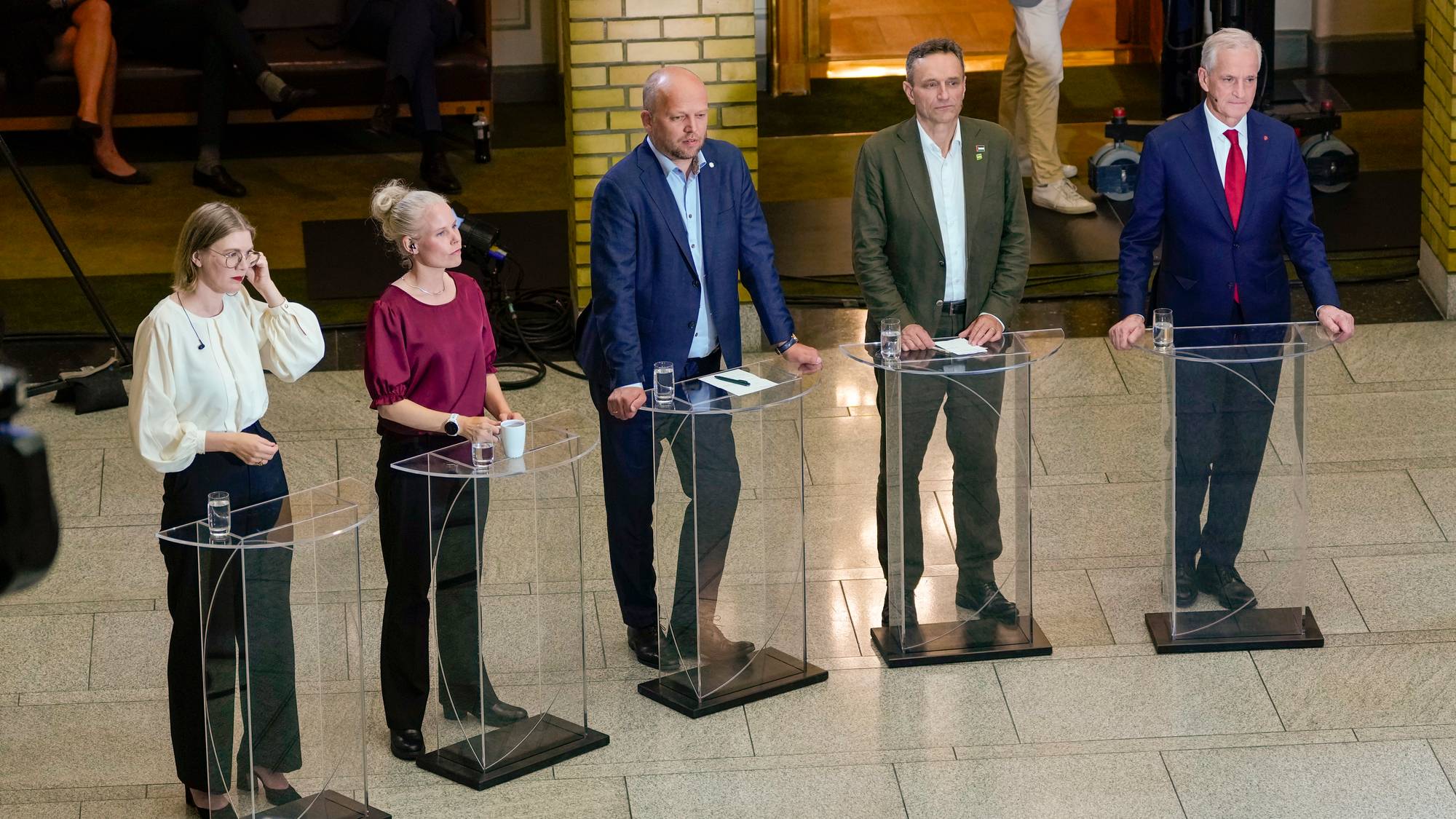 Trygve Slagsvold Vedum m.fl. stående på et flislagt gulv