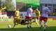 Thomas Andersen / NTB En fotballspiller i gult faller mot bakken. En annen spiller i hvitt forsøker å takle ham. Flere spillere er synlige i bakgrunnen på fotballbanen. (Bildebeskrivelsen er laget av en KI-tjeneste)