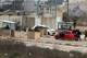 写真:Zain Jaafar / AFP / NTB 人々のグループと一緒に建物の前に駐車した赤い車