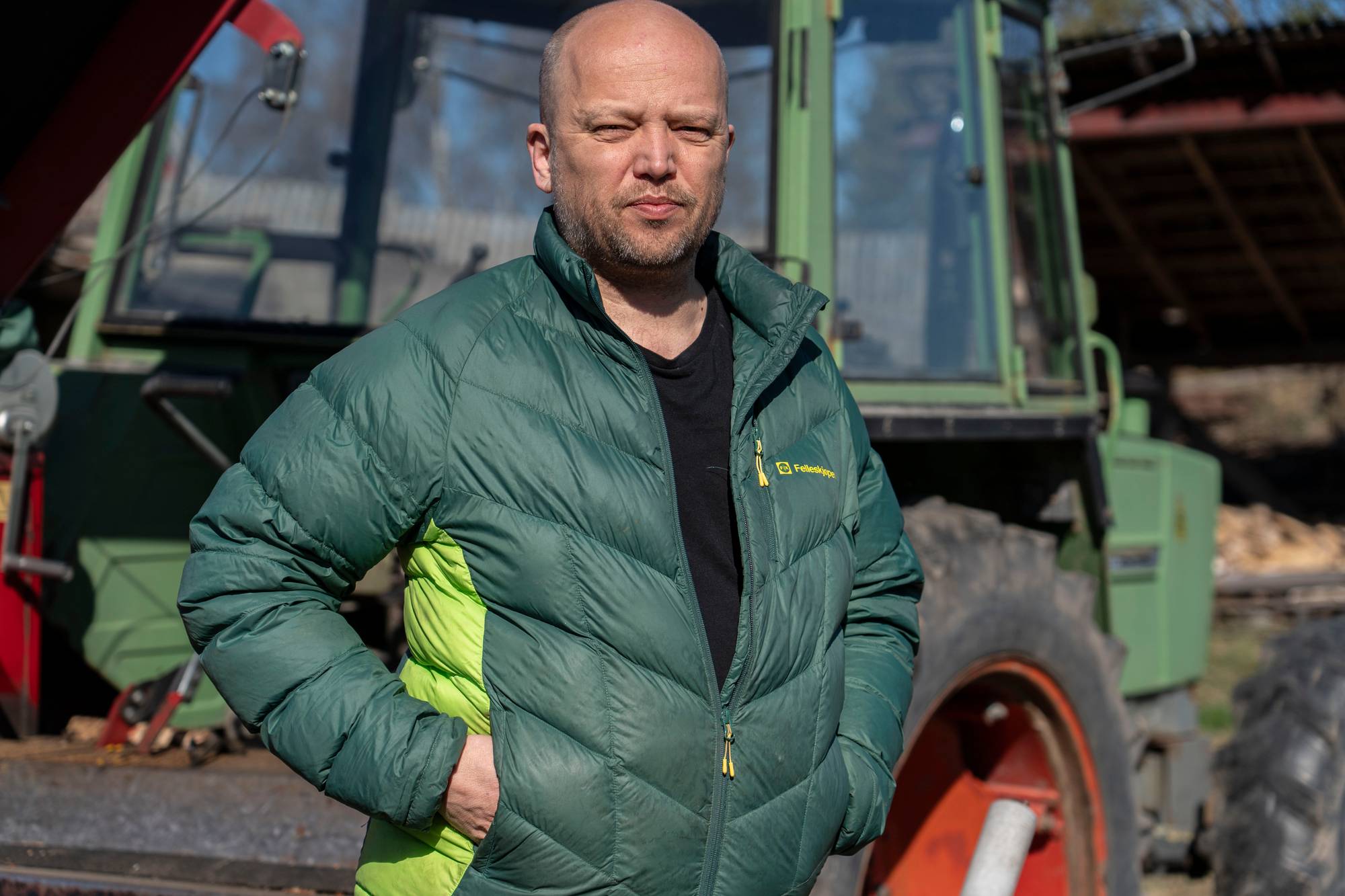 Vedum foran traktor hjemme på gården. Traktor i bakgrunn