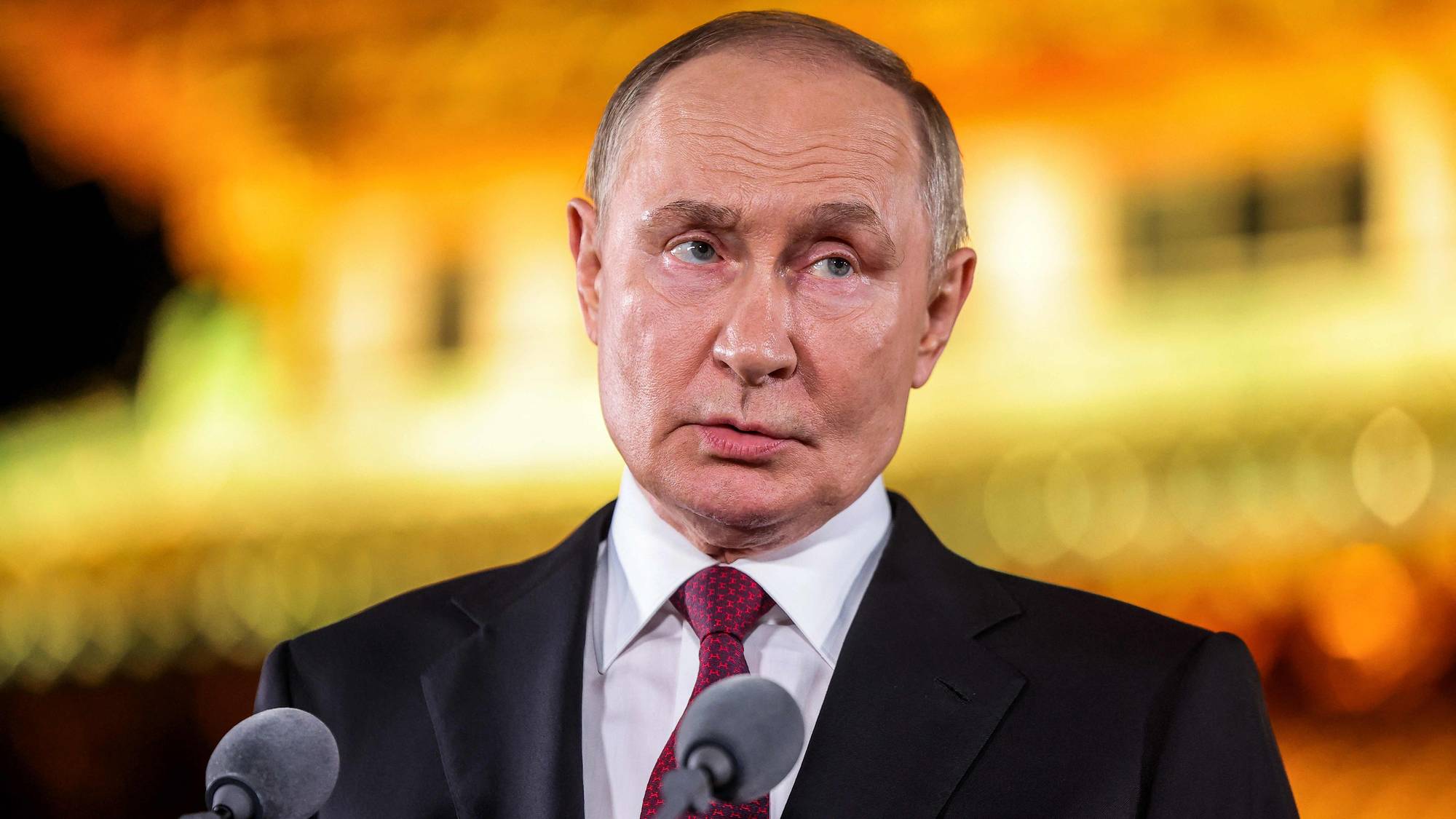 President i Russland, Putin, står foran to mikrofoner.