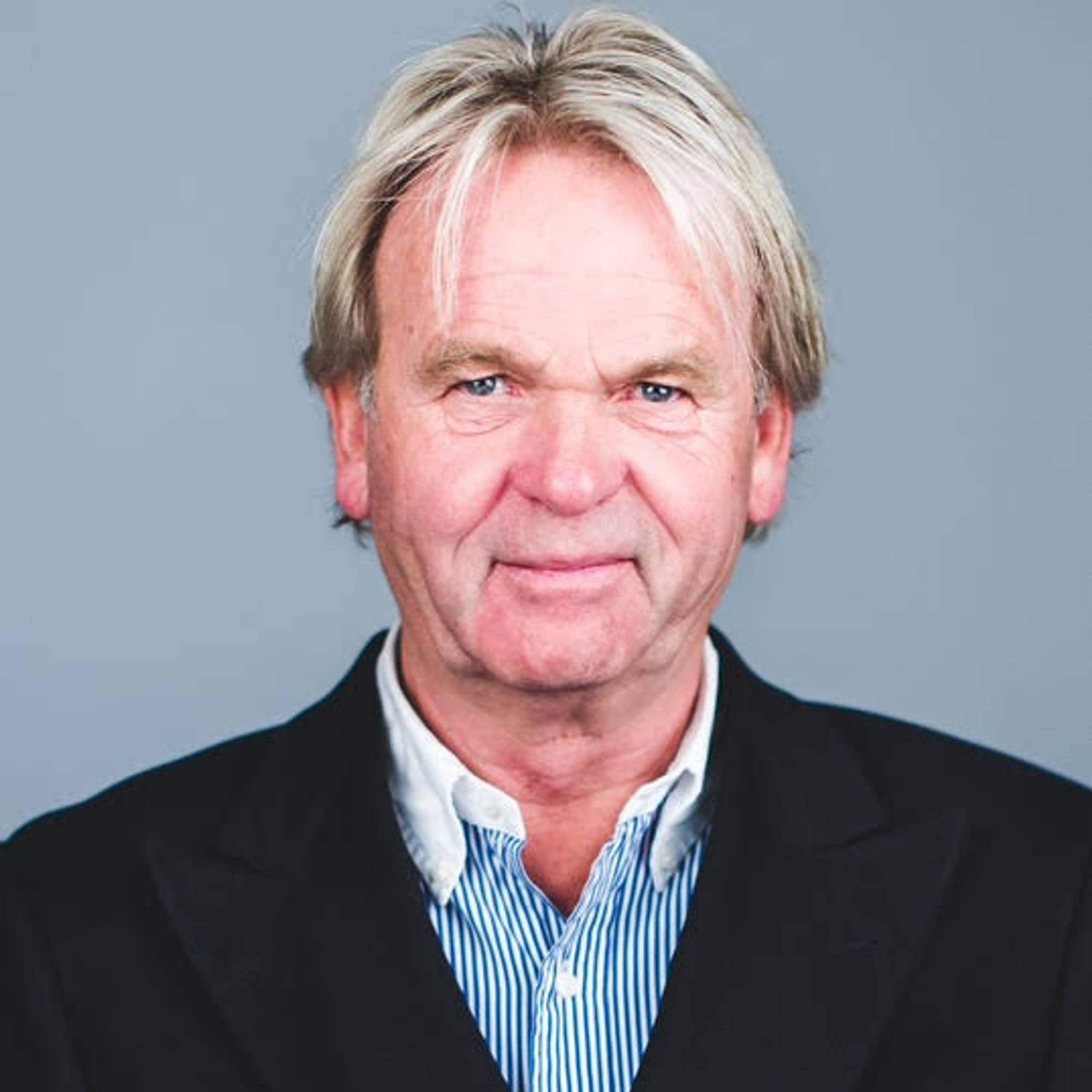 Mann med dressjakke ser inn i kameraet