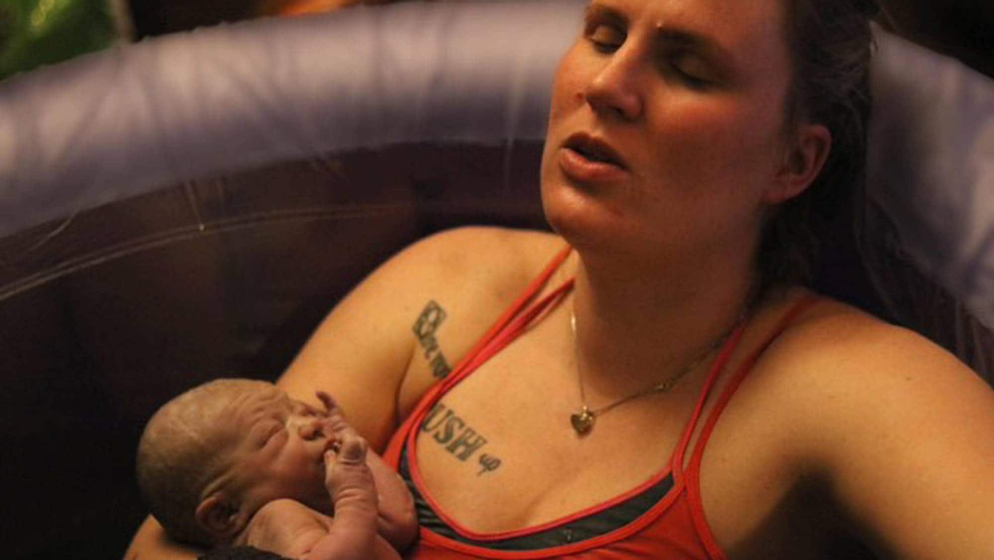 Kristina Folkestad with newborn baby in bathtub after home birth