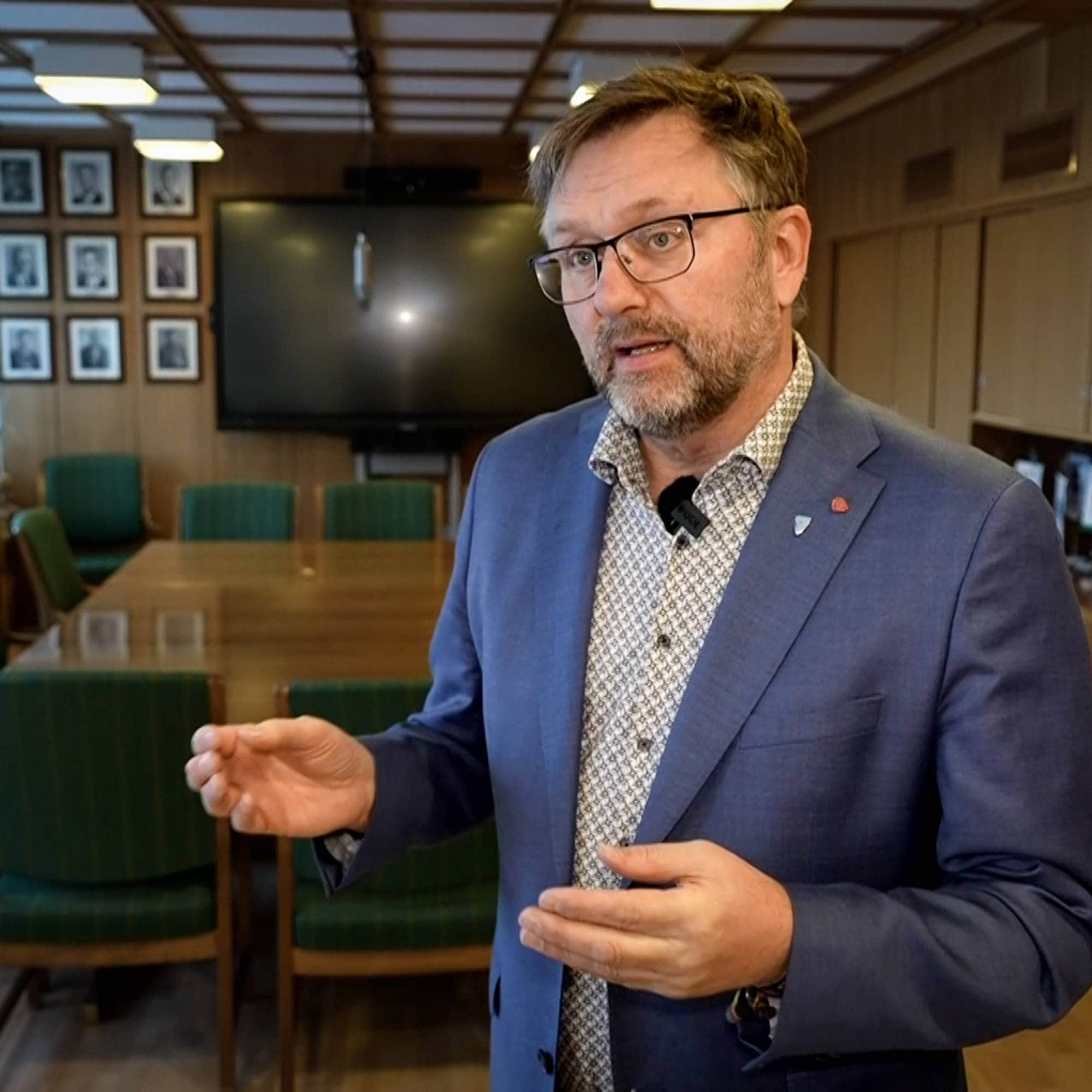 Mann i blazer forklarer