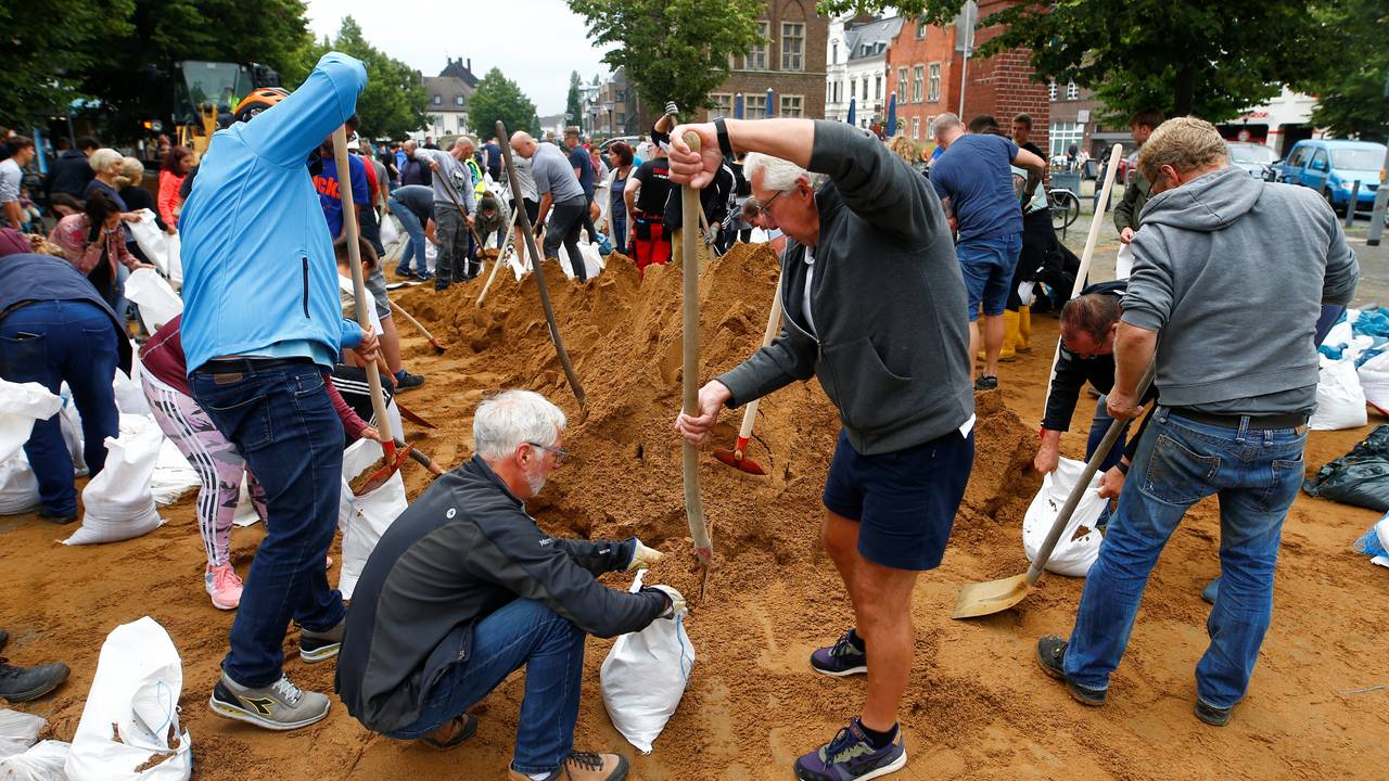 Innbyggere i Erftstad hjelper til med å fylle sand i bager som skal brukes til å hindre at vannmassene.