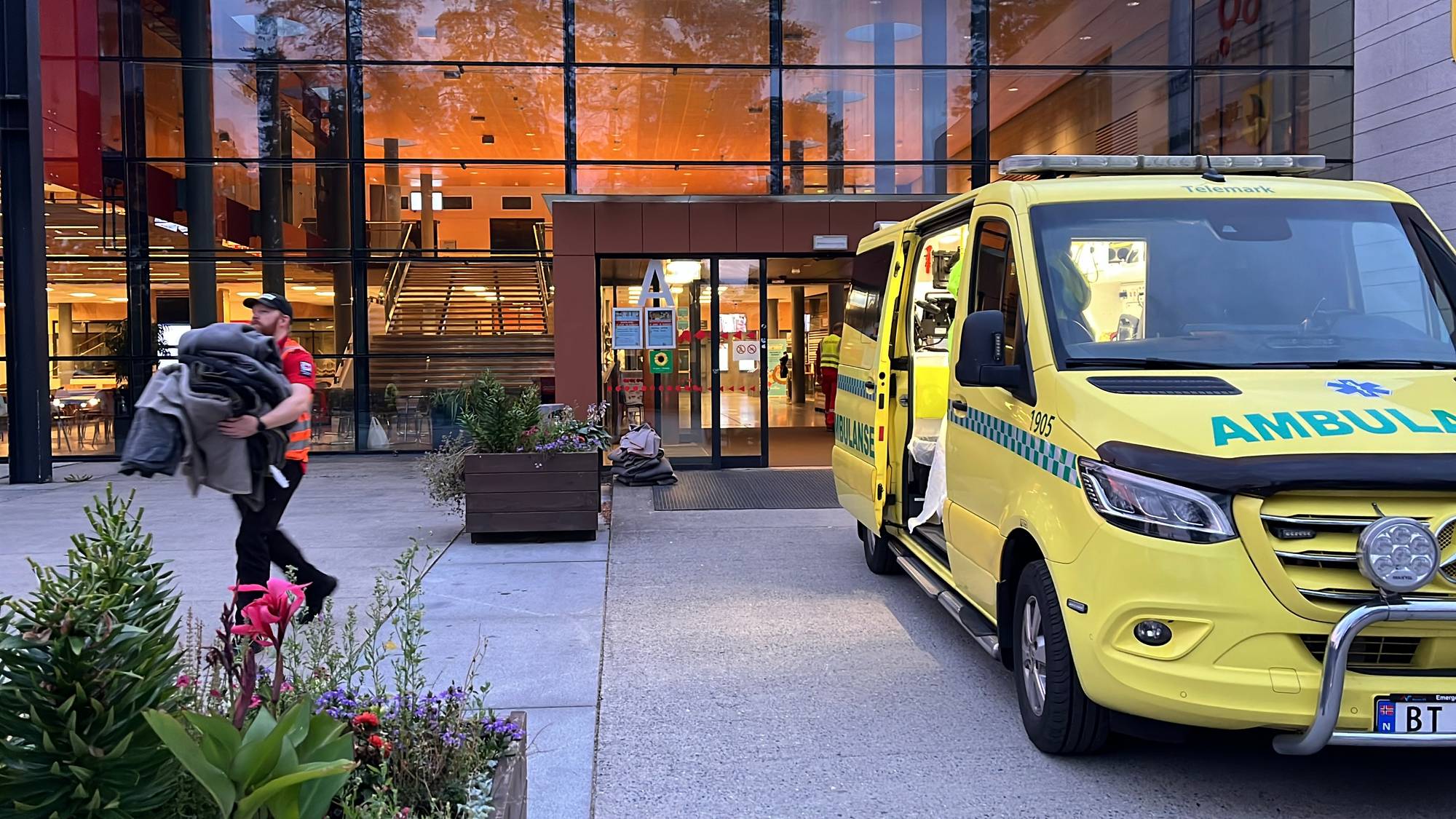 ambulansebil og mann som bærer pledd