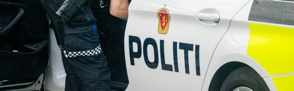 en politimann som står ved siden av en bil