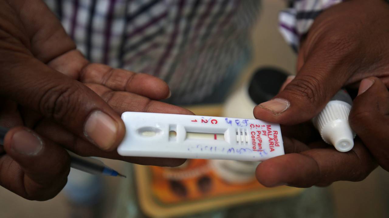 En helsearbeider i India viser frem en hurtigtest for malaria.