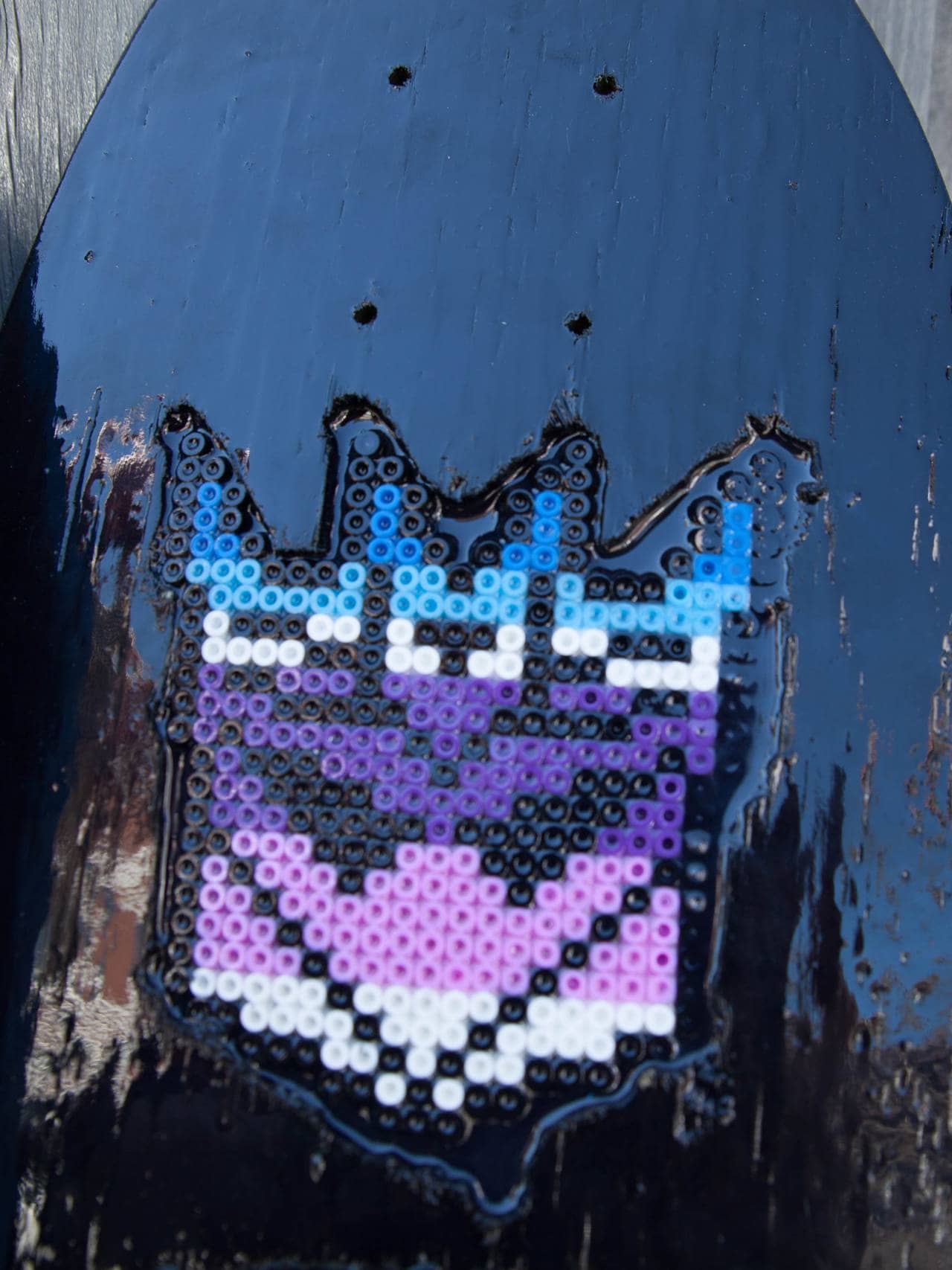 Detalj av det perla motivet på et svartlakkert, glinsende skateboard