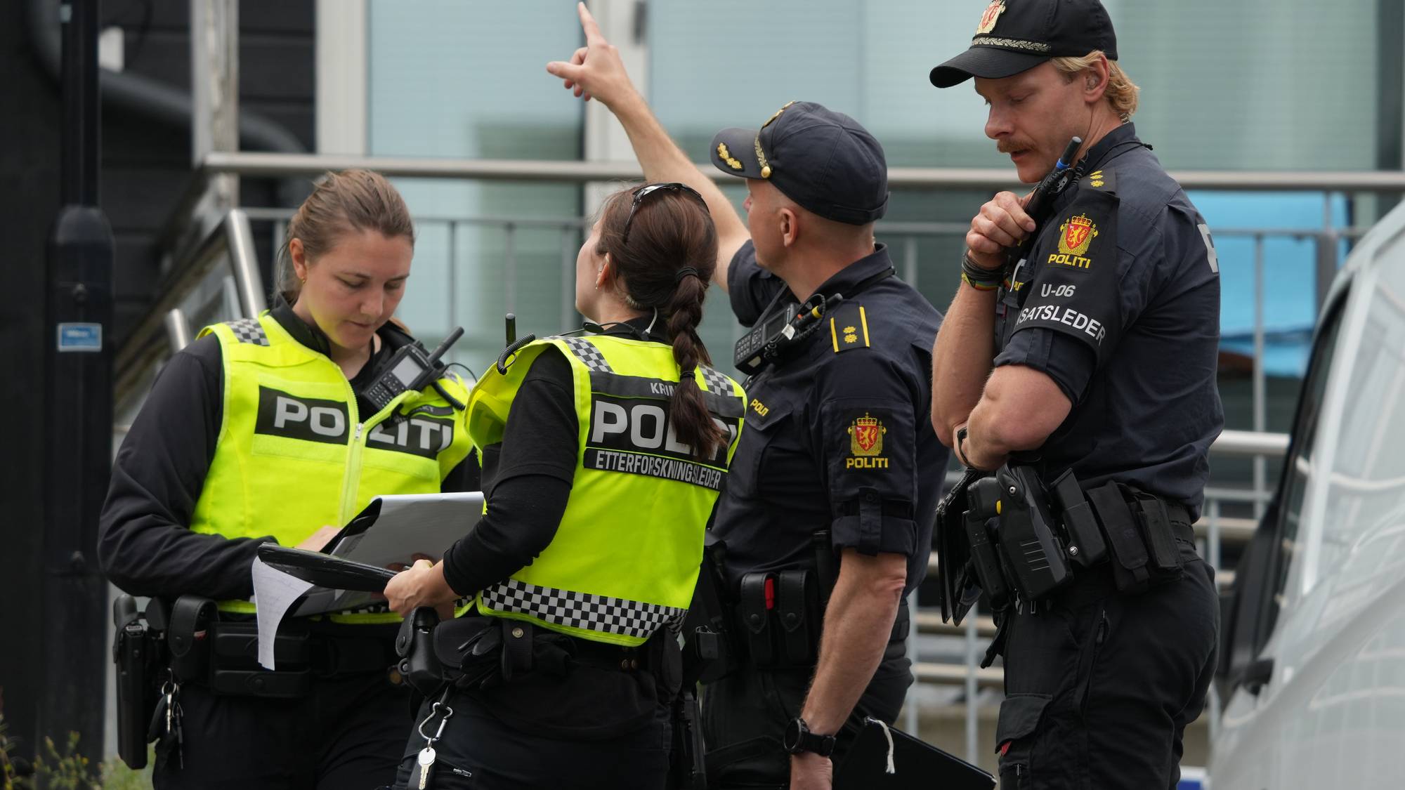 Fire politibetjenter i uniform samlet på et åsted mens en peker oppover. (Bildebeskrivelsen er laget av en KI-tjeneste)