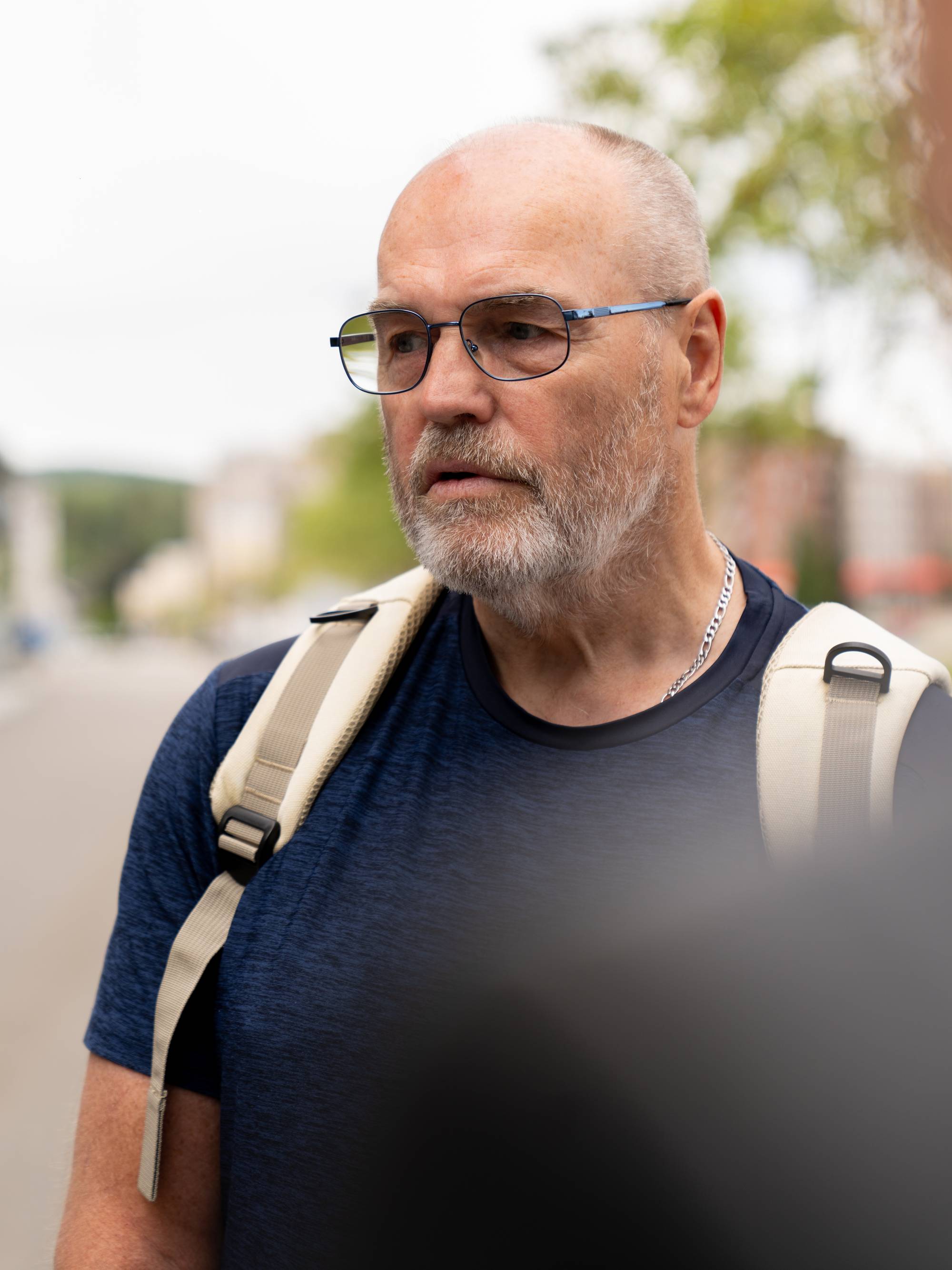 Einar Strand i briller, blå t-skjorte og ryggsekk