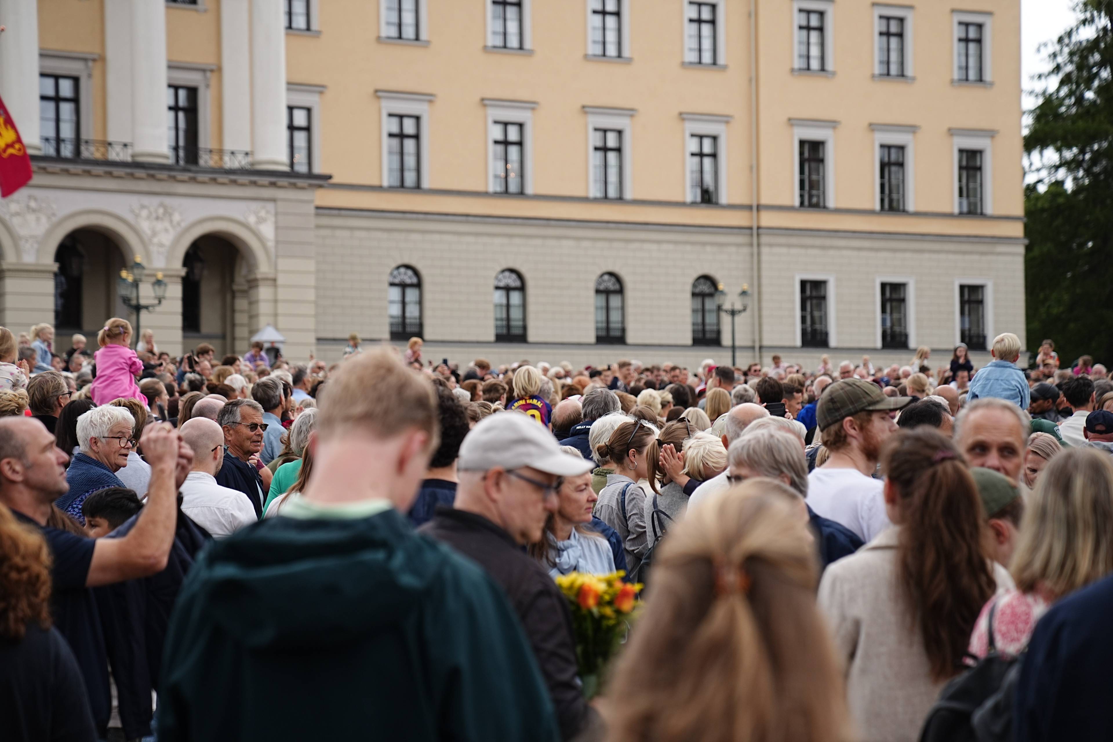 En stor folkemengde er samlet foran Det kongelige slott i Oslo.
