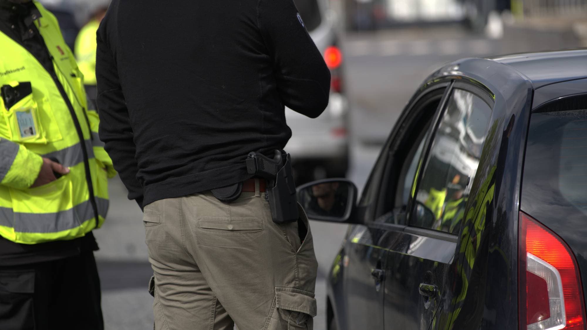 A-krim-aksjon ved Bontelabo i Bergen: kontrollør i svart genser står med pistol i beltet står ved ein bil