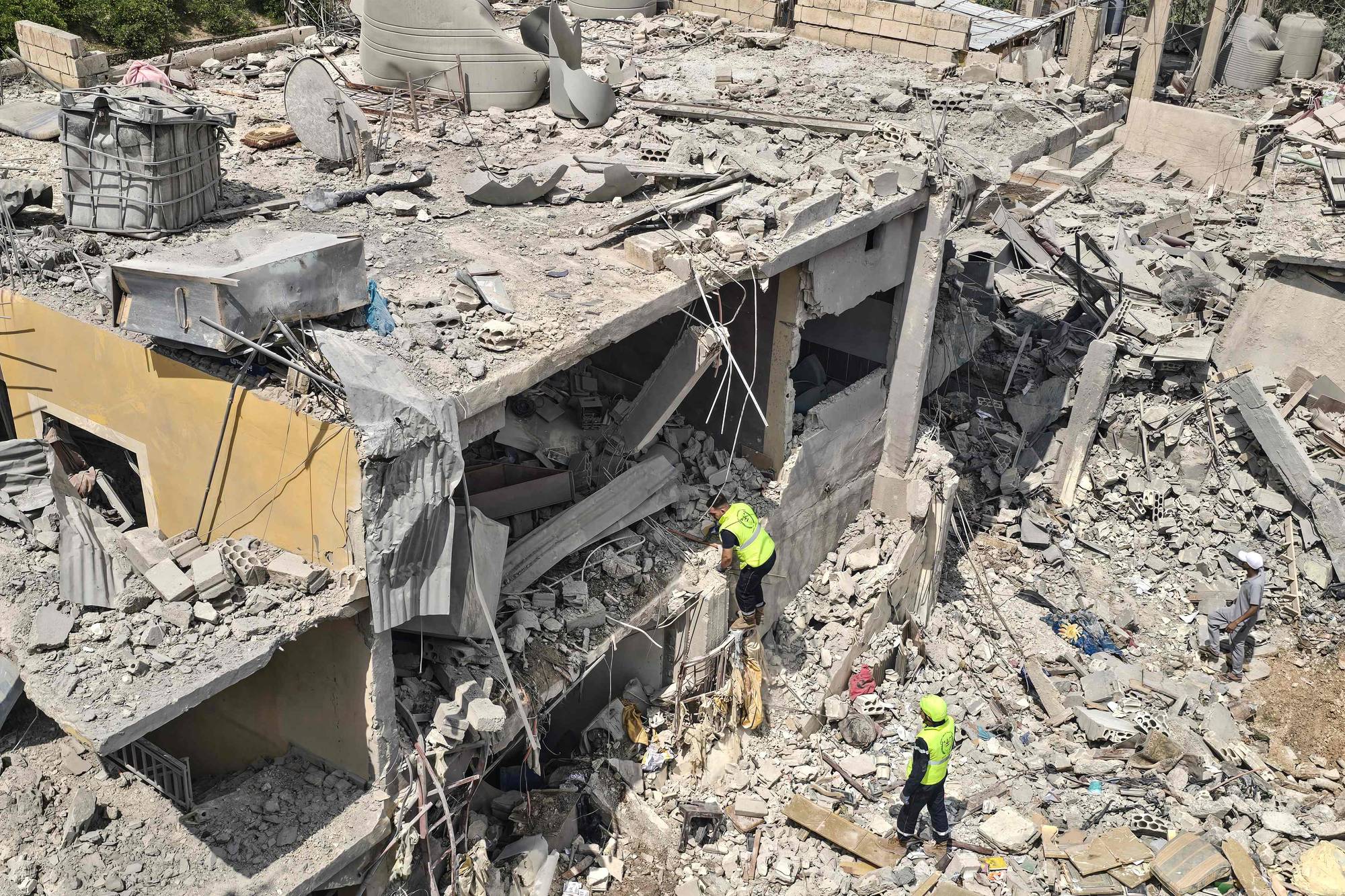 En helt ødelagt bygning der redningsarbeidere søker etter overlevende etter bombeangrep. 