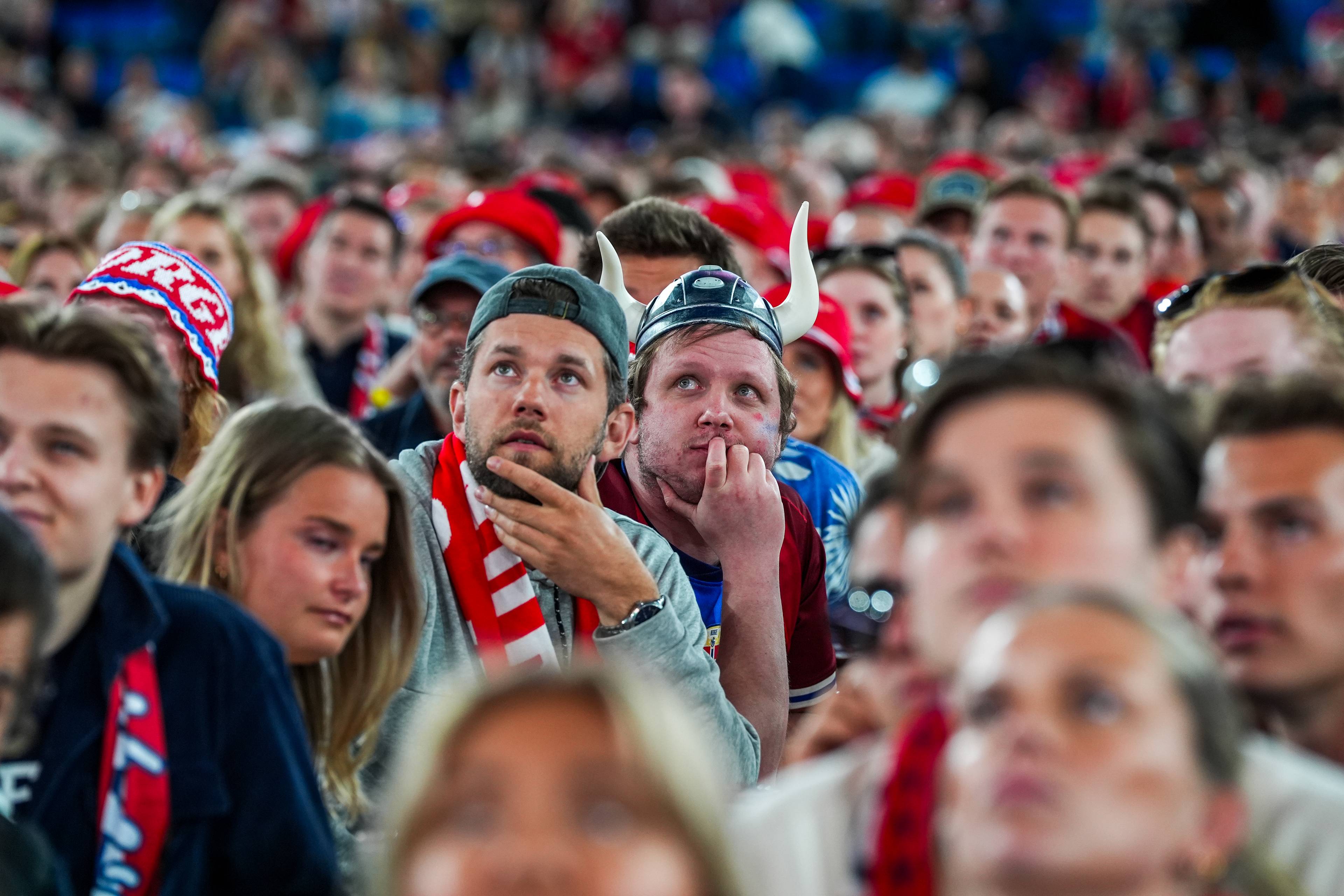 i en folkemengde ser vi to spente menn i fokus, de har på vikinghjelmer