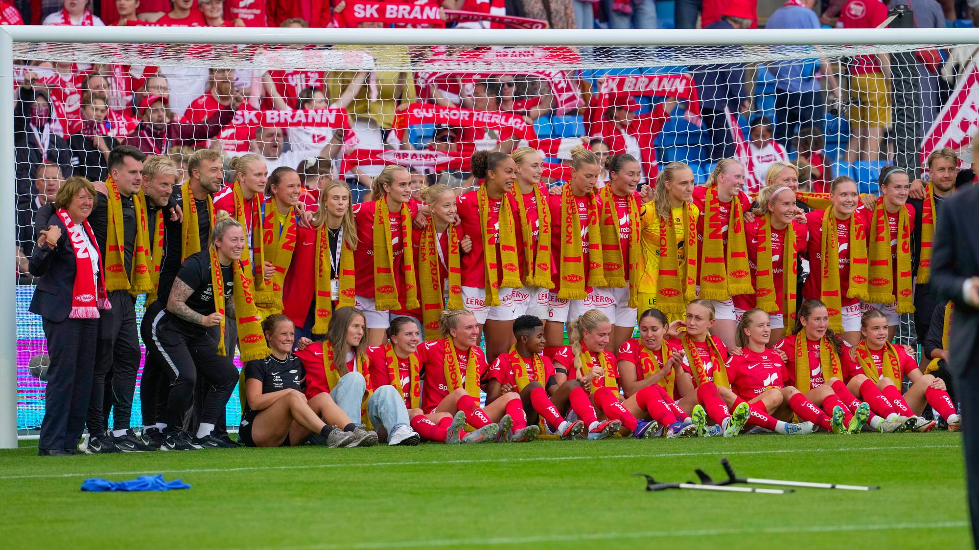 Spillere og støtteapparat fra SK Brann kvinner jubler foran supportere etter fotballkamp. (Bildebeskrivelsen er laget av en KI-tjeneste)