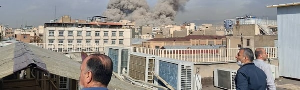 Tre menn ser på røyk kommer opp i Teheran