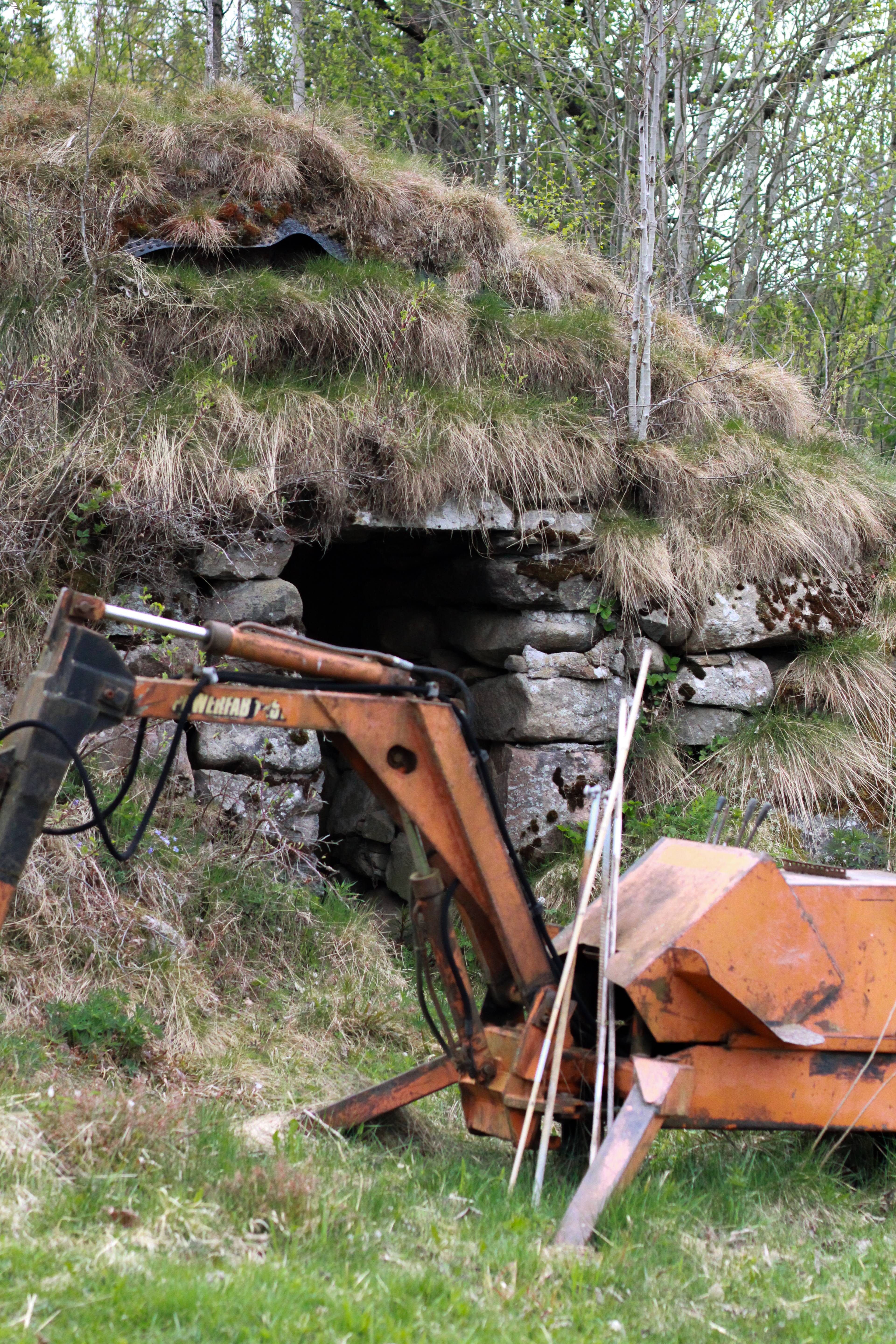 En maskin i skogen foran en steinhytte