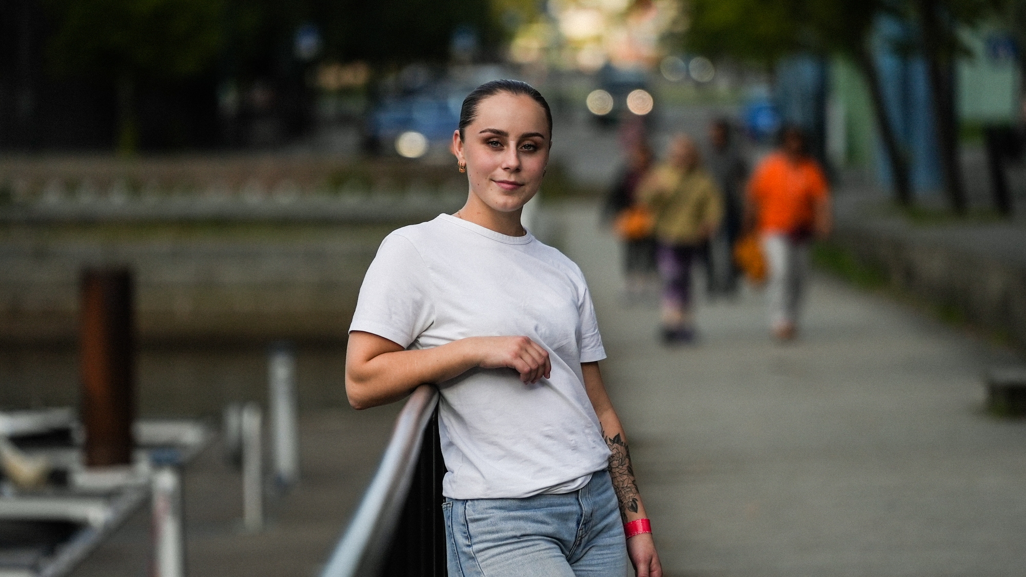 Bilde av Ingeborg Wahl som lener seg på et gjerde. Hun har på seg hvit T-skjorte og jeans. Håret er trukket bak i en 