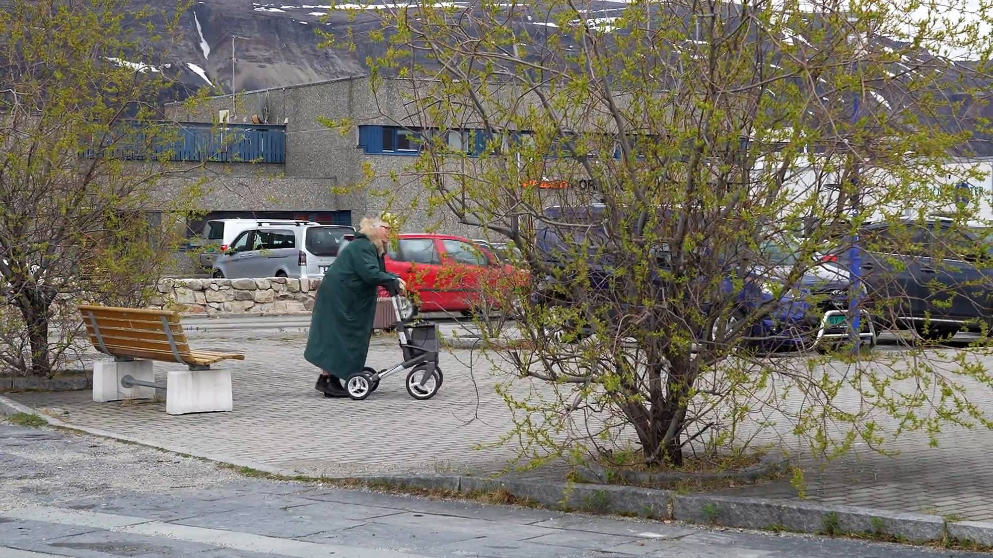 En eldre kvinne går med rullator i Lakselv.