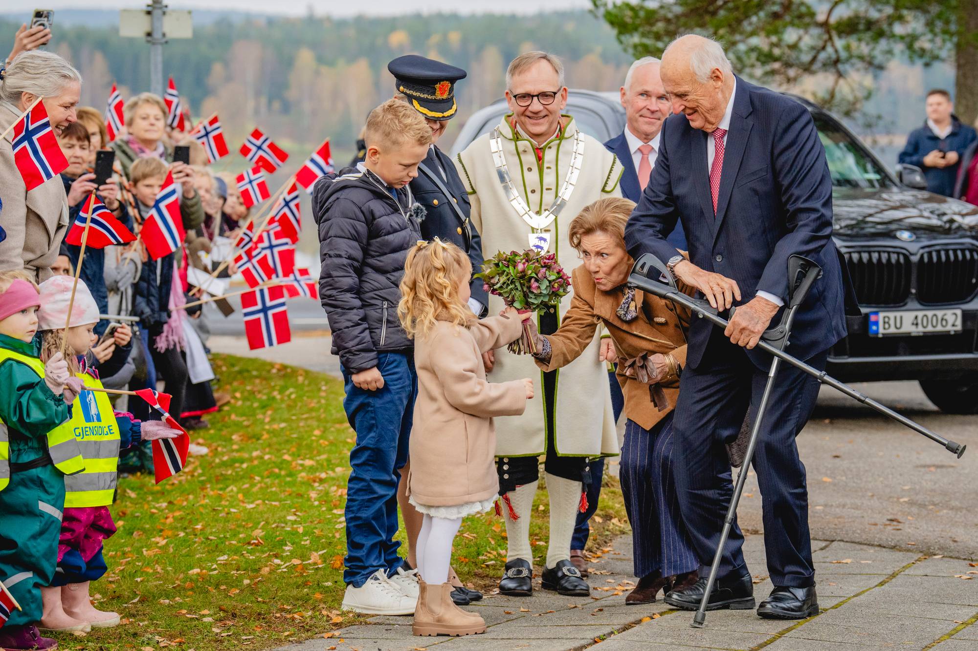 Kongeparet blir møtt av blomsterbarn når de ankommer Aremark i oktober 2025.