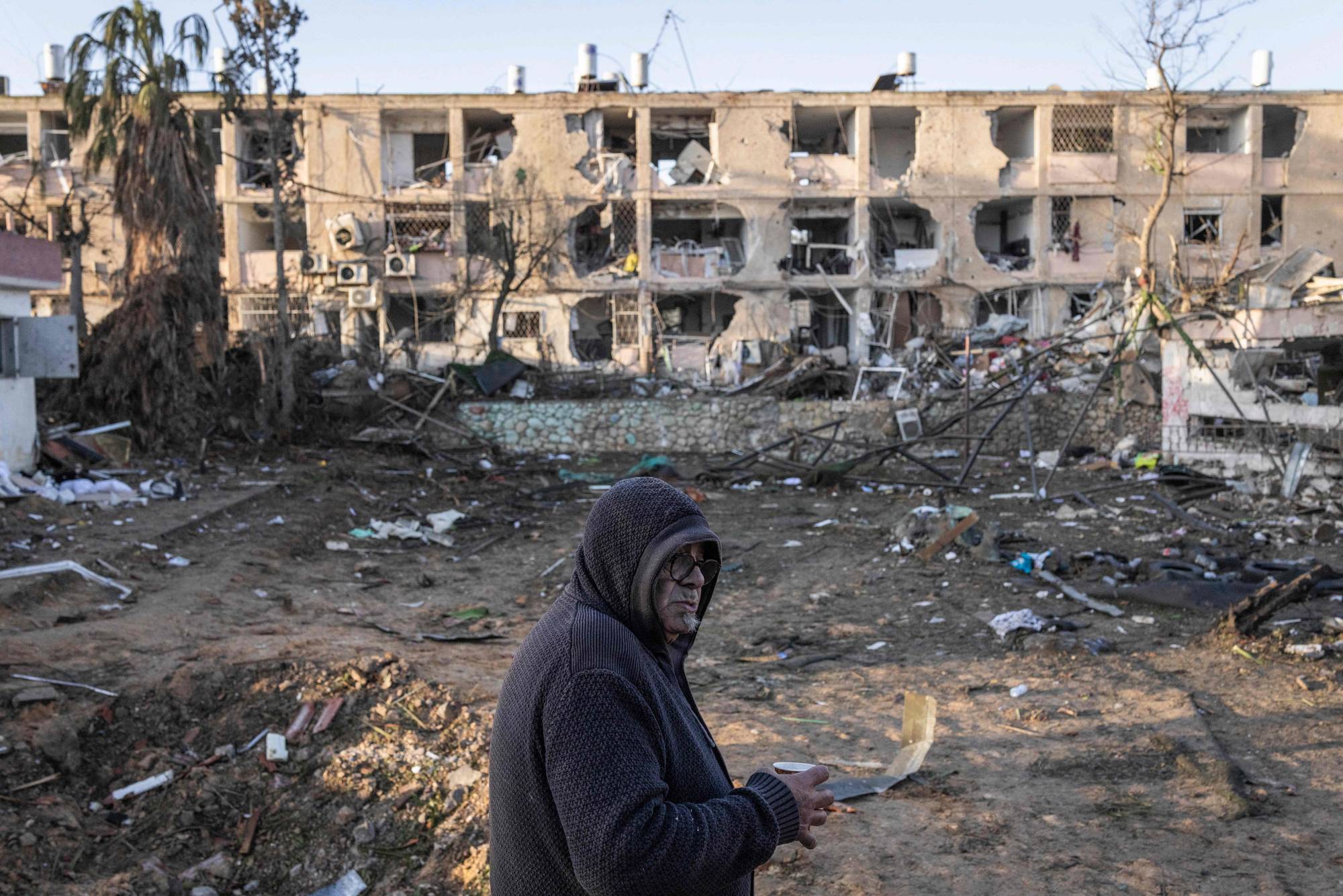 En mann står foran en ødelagt boligblokk i Dimona, Israel etter et iransk angrep. 