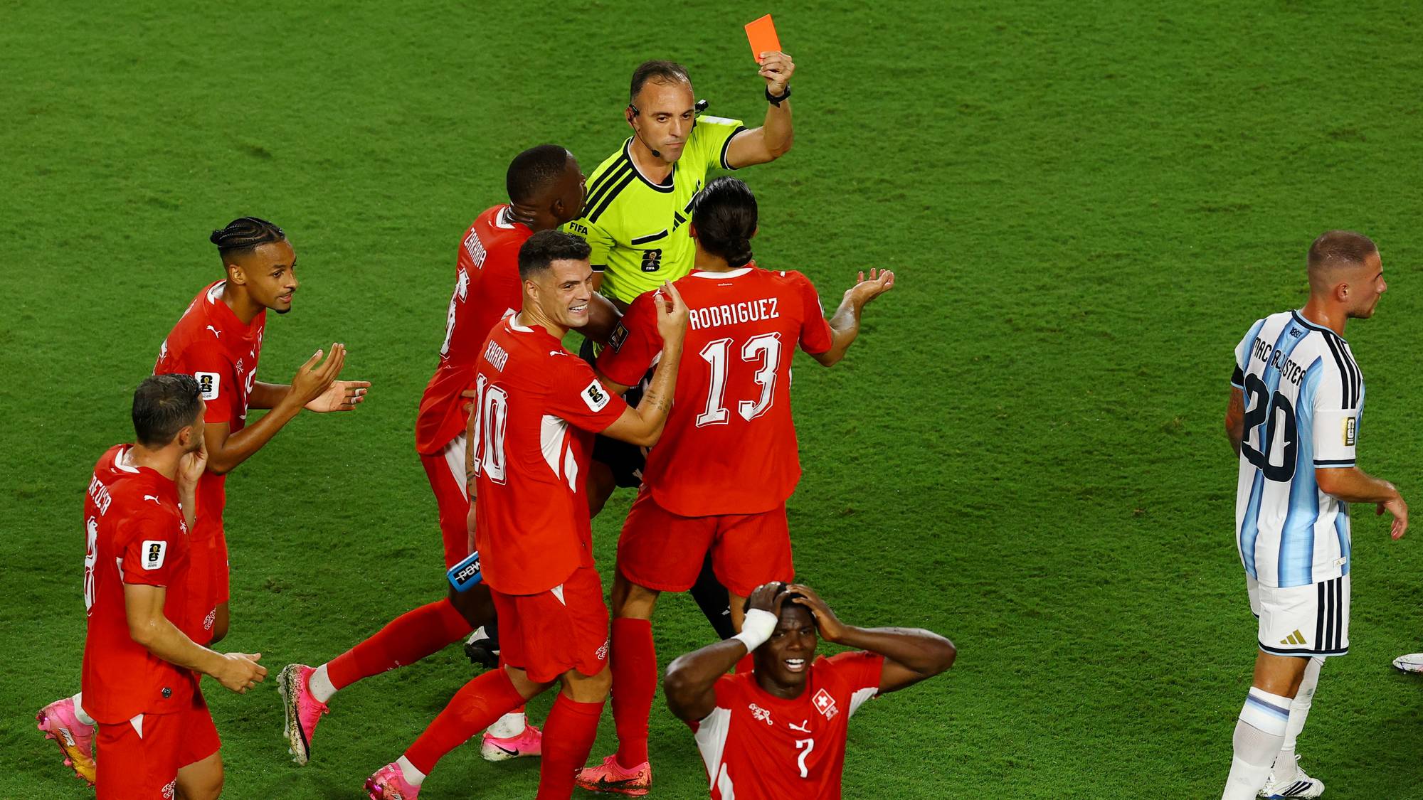 Dommer viser rødt kort til en sveitsisk fotballspiller mens lagkamerater reagerer. (Bildebeskrivelsen er laget av en KI-tjeneste)
